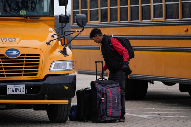 <p>An arriving migrant departs a school bus in the 800 block of South Desplaines Street</p>