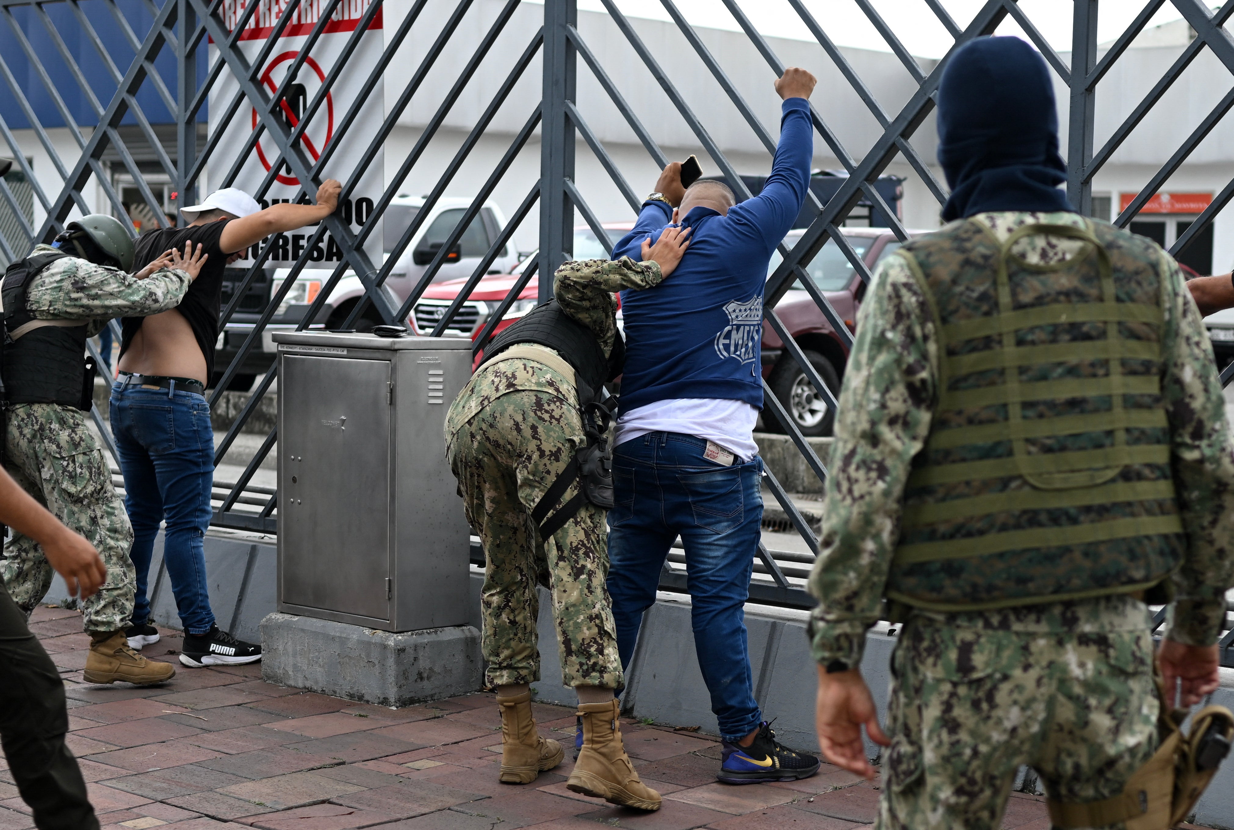 Soldiers frisk two men suspected of belonging to a criminal gang in Guayaquil