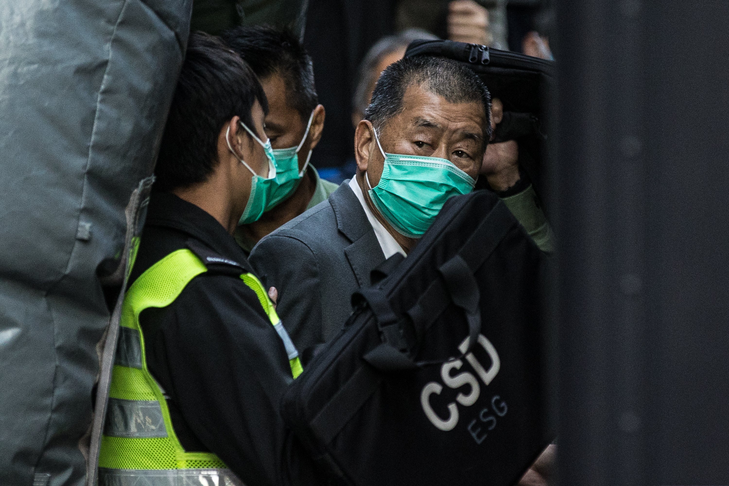 Pro-democracy media tycoon Lai (R) is escorted into a correctional services van outside the Court of Final Appeal in Hong Kong in 2021