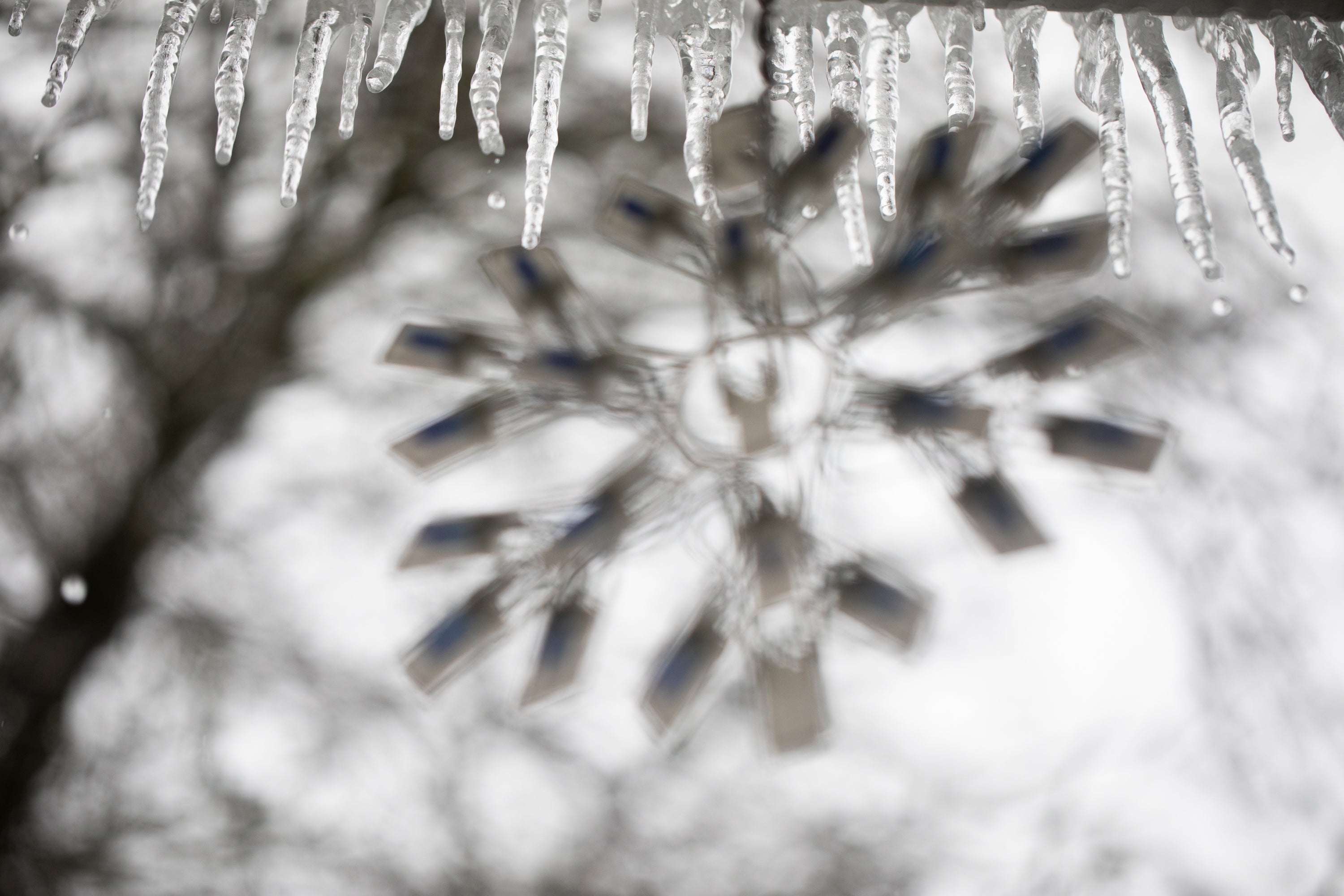 Icicles hang by a snowflake on a string light