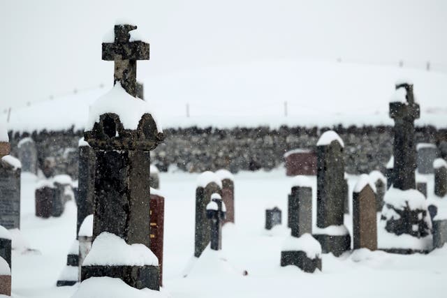 <p>Snow gathers on top of gravestone in Lairg Cemetery in January </p>