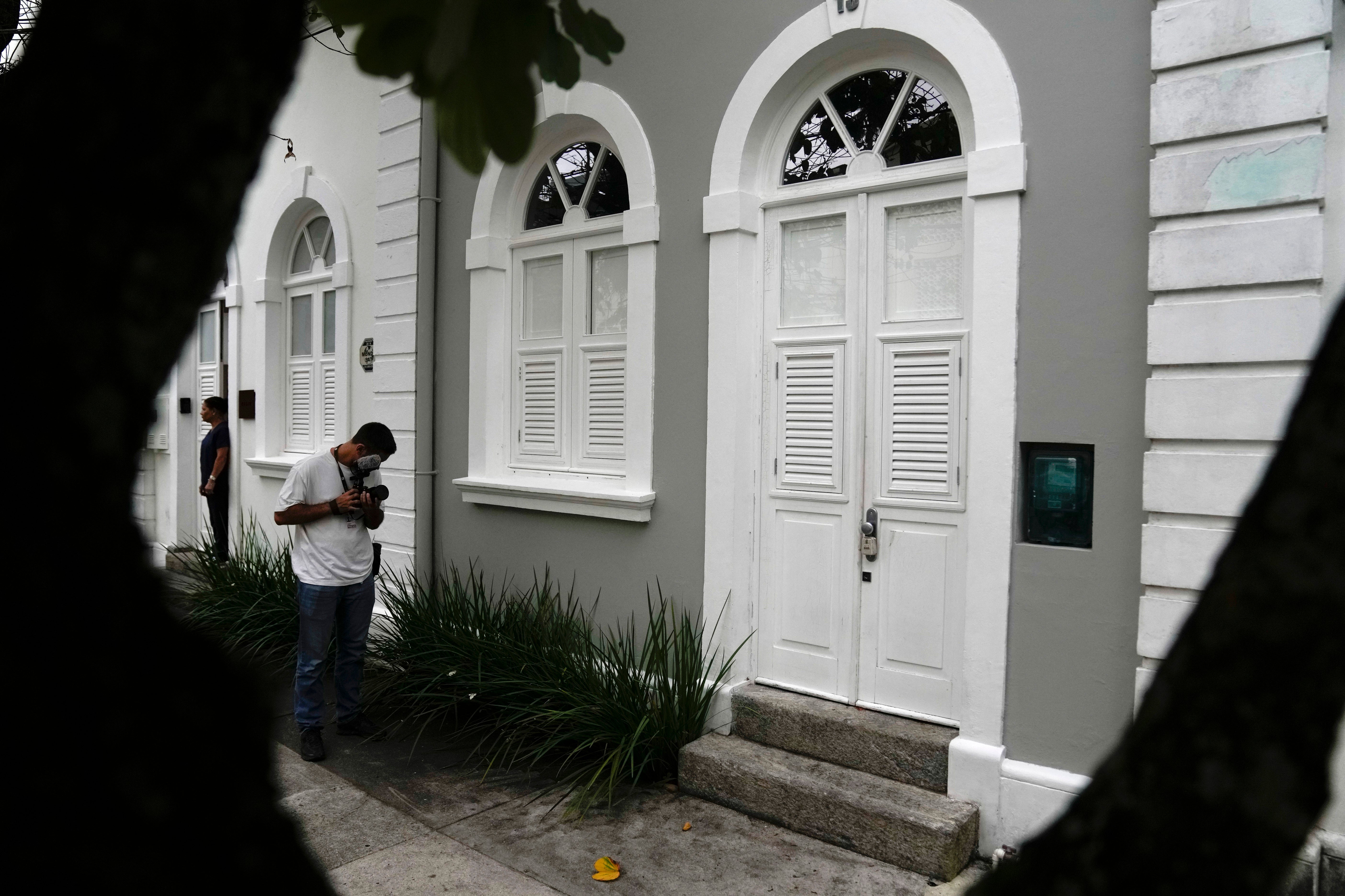 A journalist films the entrance to the apartment where Brent Sikkema, an American art dealer, was found dead, in Rio de Janeiro, Brazil