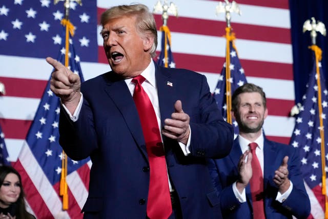 <p>Republican presidential candidate Donald Trump points to the crowd, accompanied by his son, Eric, at a caucus night party in Des Moines, Iowa, Monday, Jan. 15, 2024</p>
