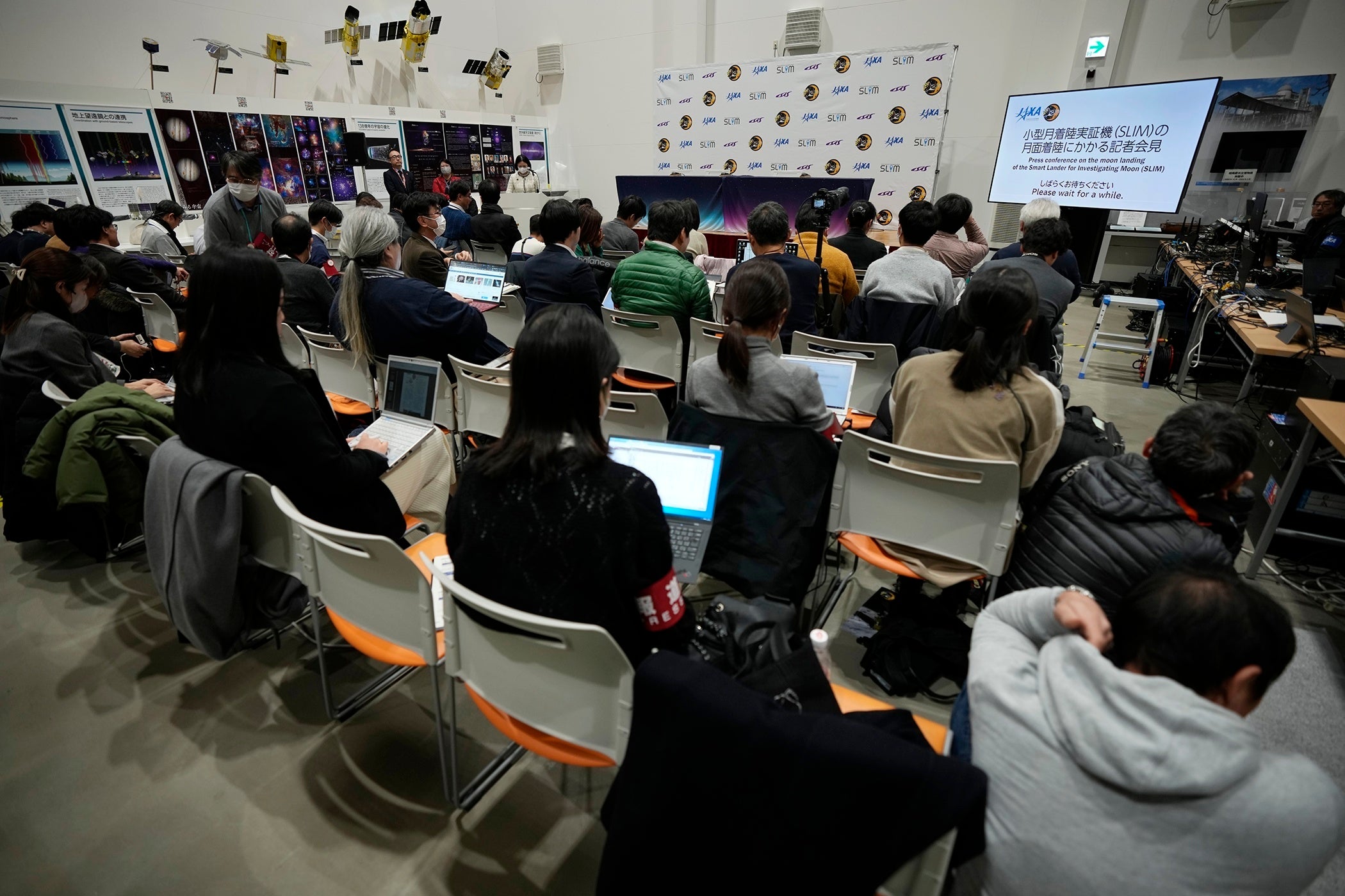Journalists wait for an update on the success of the moon landing at JAXA’s Sagamihara Campus near Tokyo
