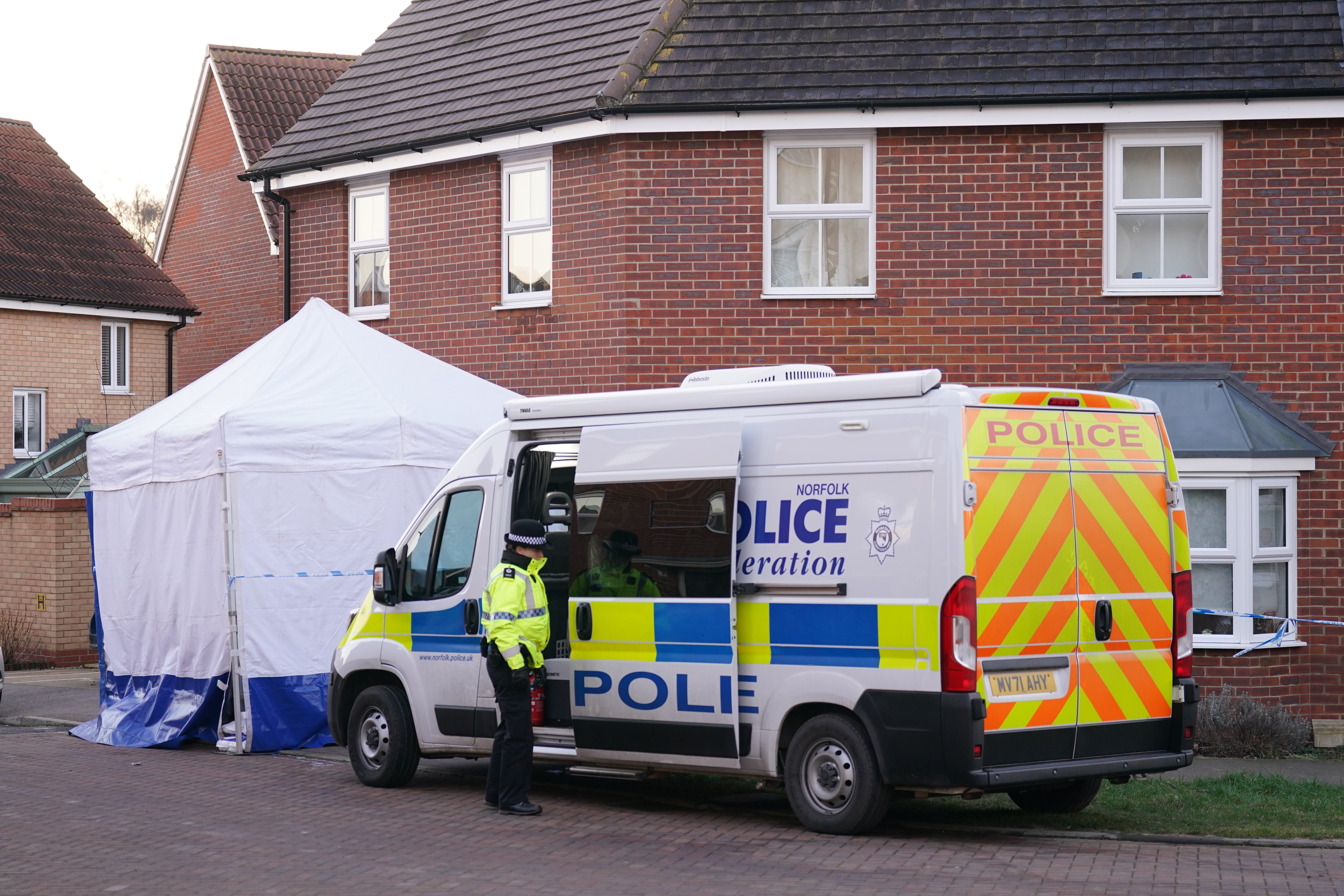 Police outside the house in Costessey near Norwich where four people were found dead