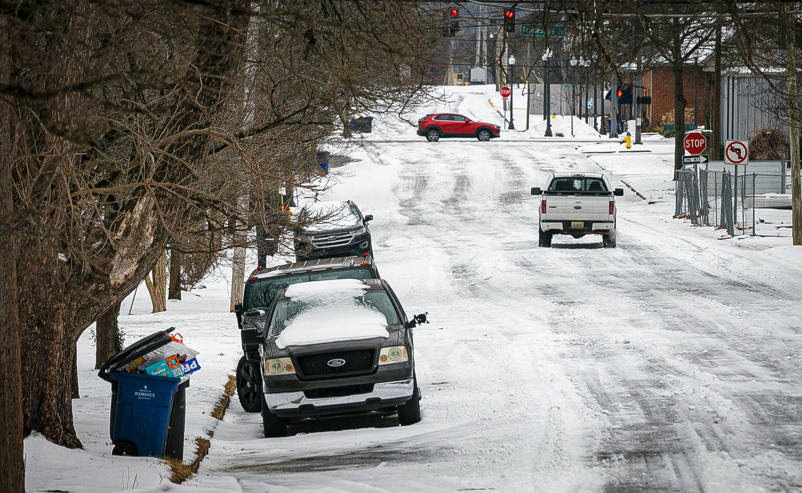 Motorists travel down a snow and ice covered road, Friday, Jan. 19, 2024 in downtown Florence, Ala. (Dan Busey/The TimesDaily via AP)