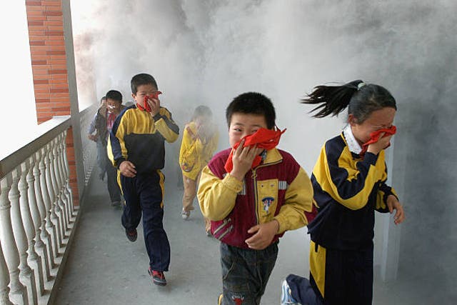 <p>Pupils evacuate from a classroom during a fire drill at a primary school in Anhui Province, China</p>