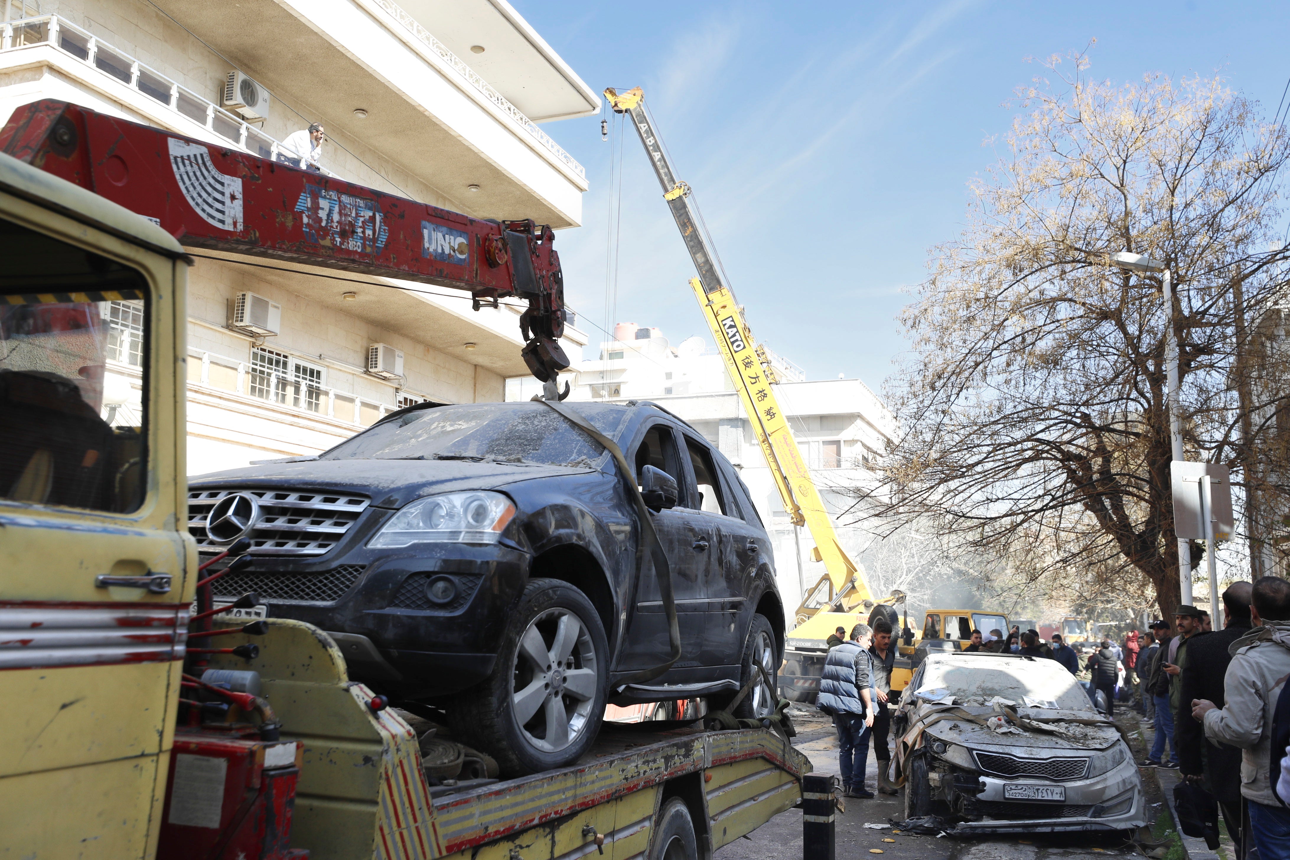 Emergency services work at a building hit by an airstrike in Damascus