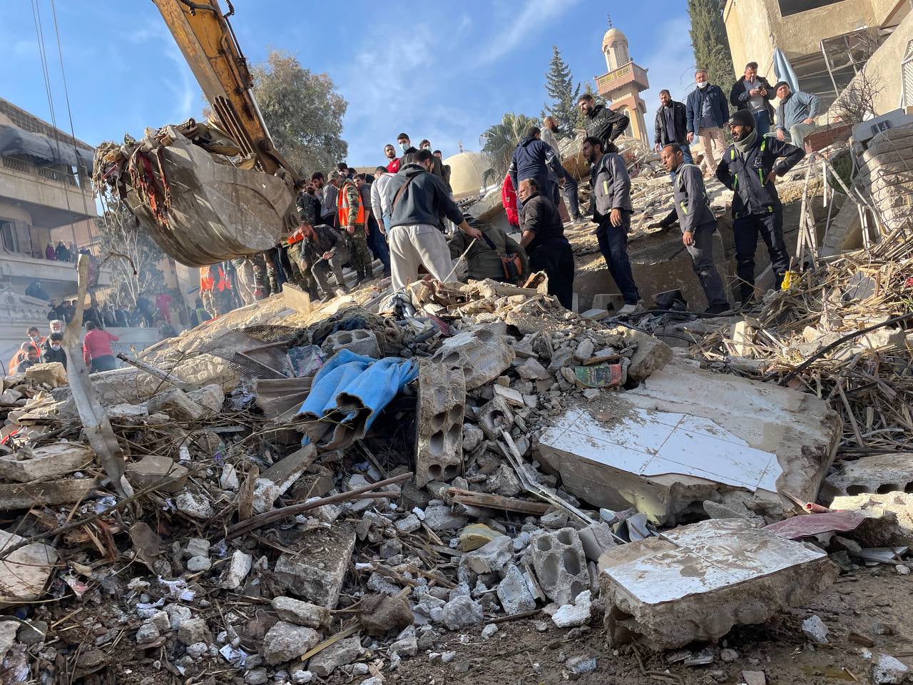 Rescuers search the rubble of the building hit by suspected Israeli airstrike