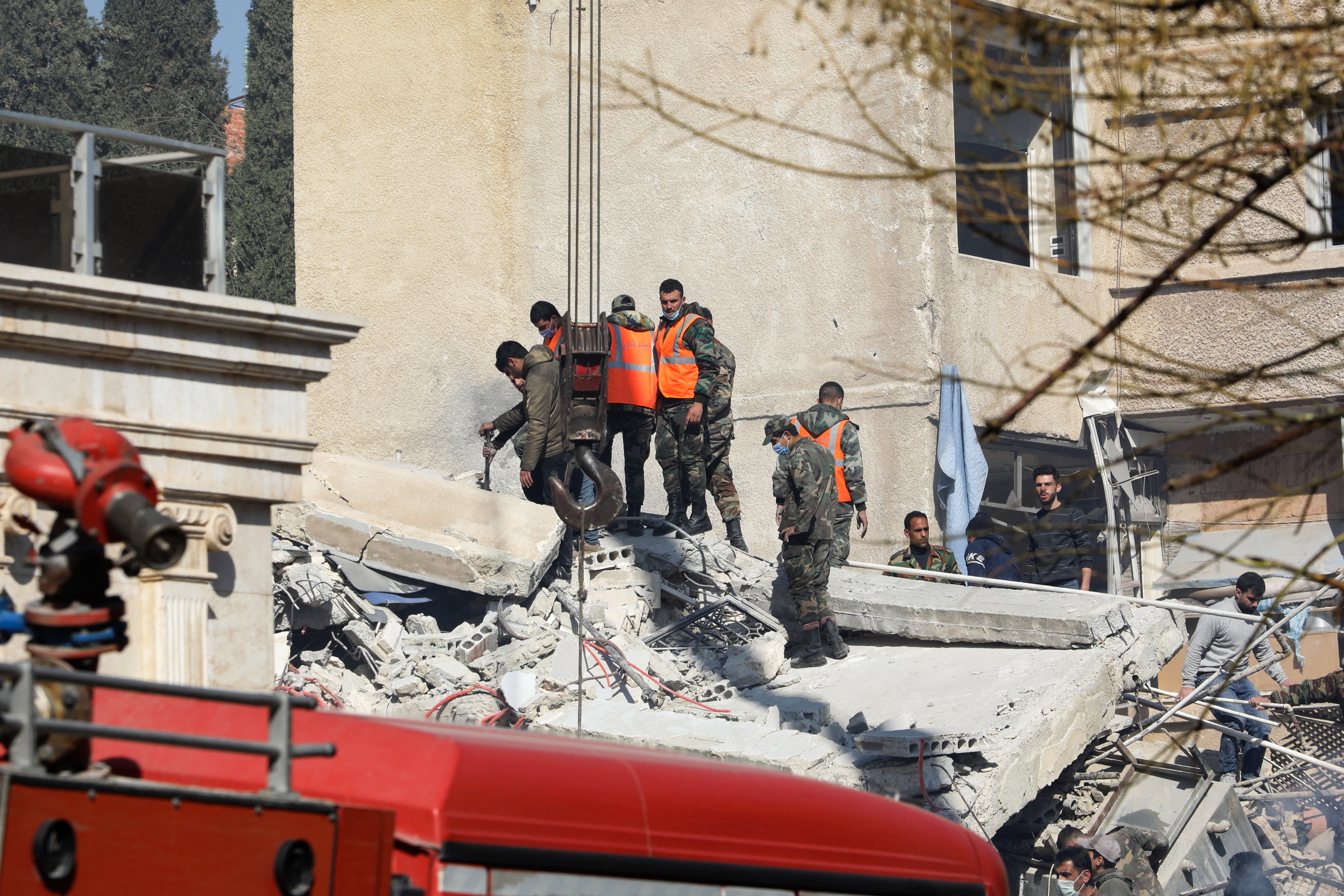 Security and emergency personnel search the rubble of the destroyed building