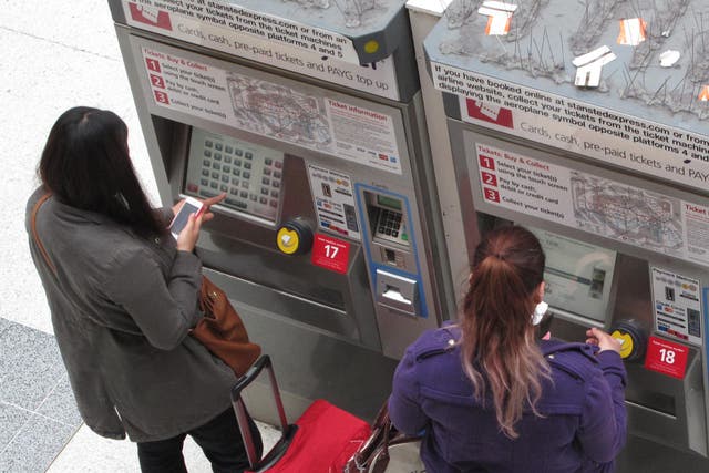 <p>Price sensitive: passengers using ticket machines at a London station</p>