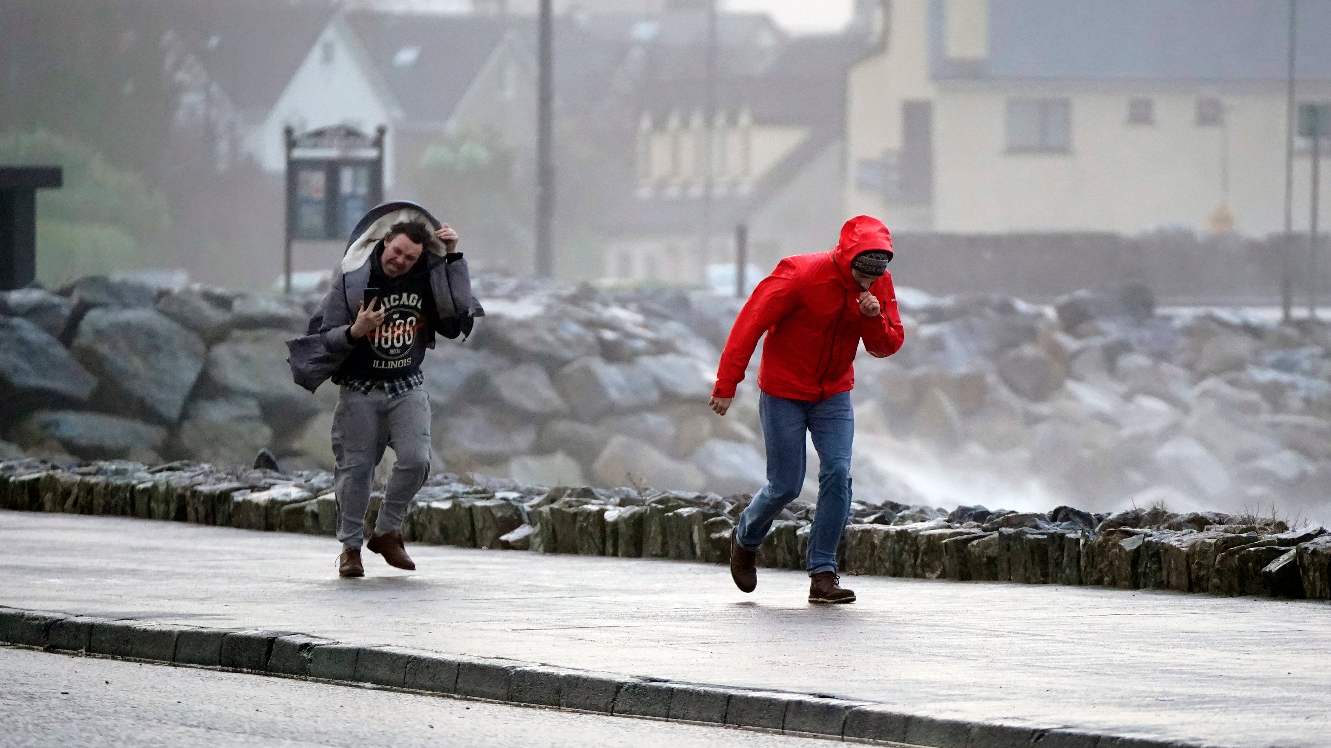 People walking in high winds at Salthill, Galway, during Storm Isha