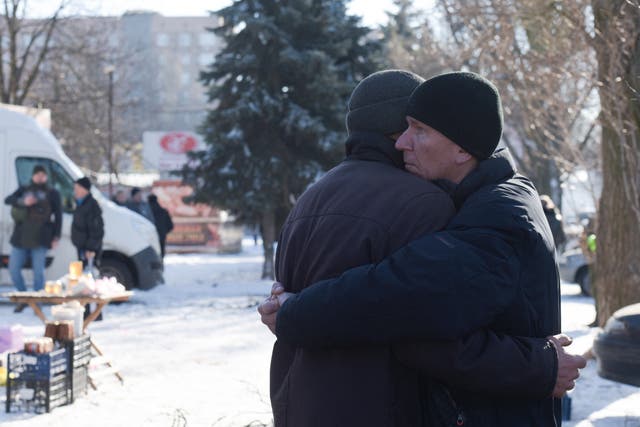 <p>Two men embrace each other at the site of a missile strike in Donetsk amid the ongoing Russian-Ukrainian conflict</p>