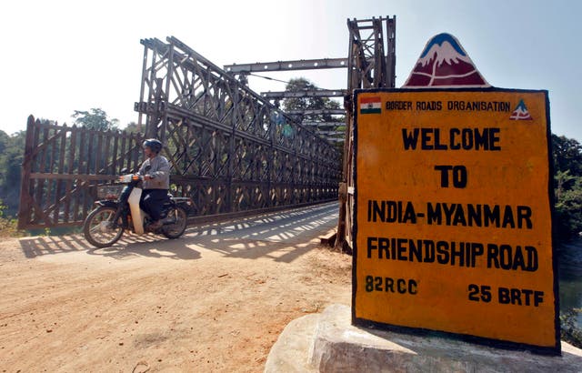 <p>A man rides his motorised two-wheeler across the Indo-Myanmar border bridge at the border town of Moreh, in the northeastern Indian state of Manipur</p>