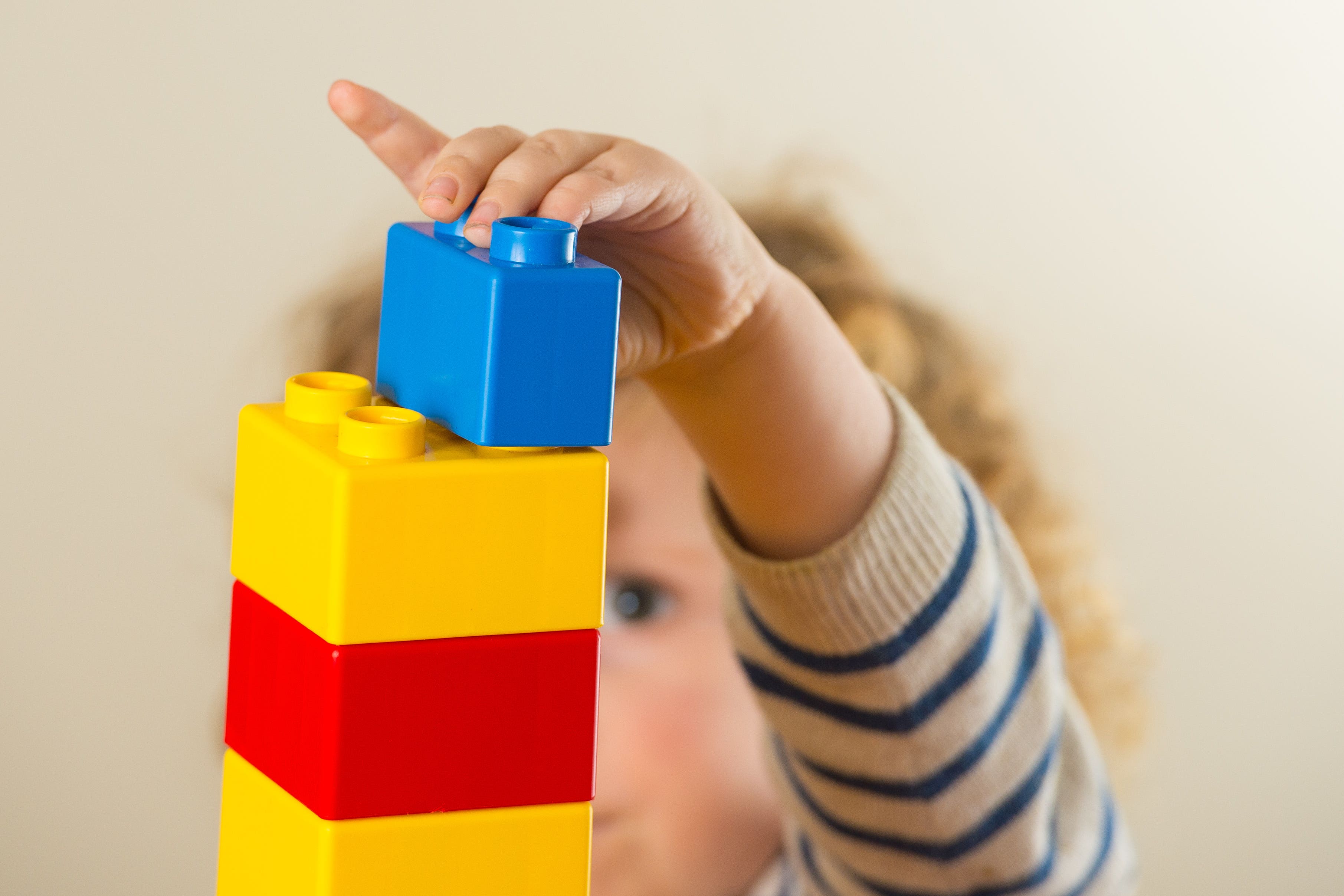 A toddler playing with plastic building blocks