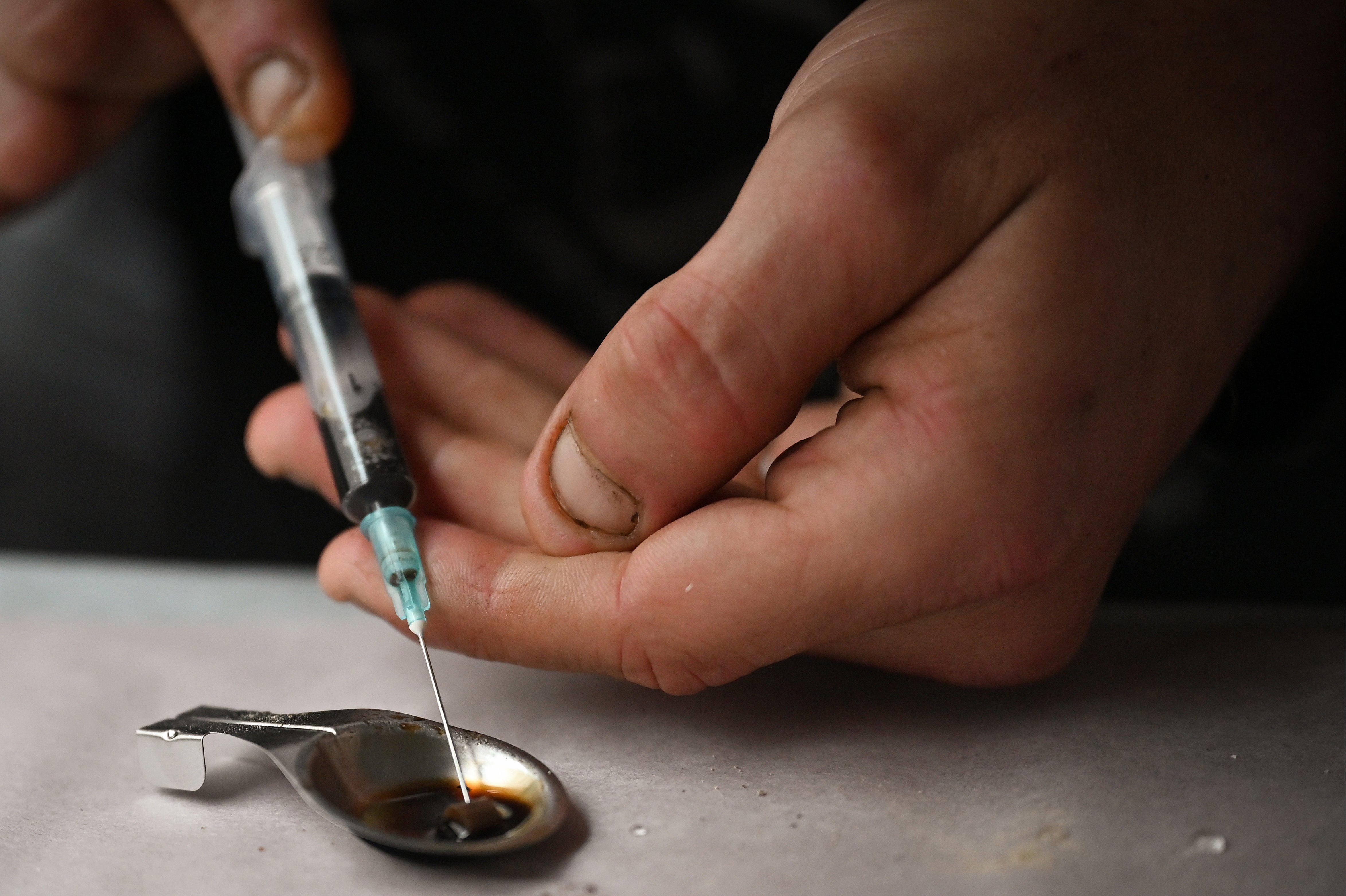 Drug users prepare heroin before injecting at a safe injection facility set up by activist Peter Krykant in Glasgow in 2020