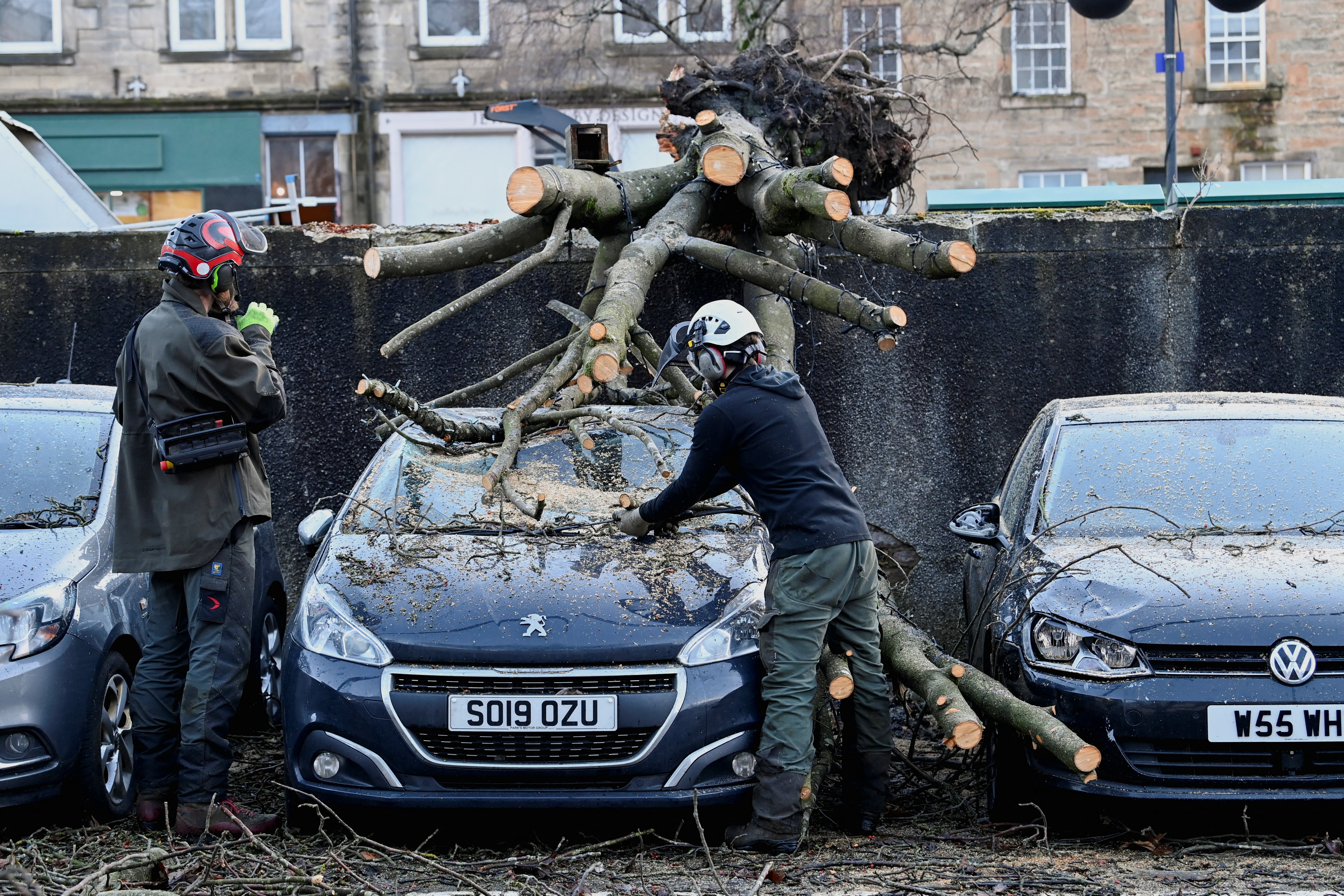 Tree surgeons remove a fallen tree from a car during Storm Isha in Linlithgow, West Lothian, Scotland