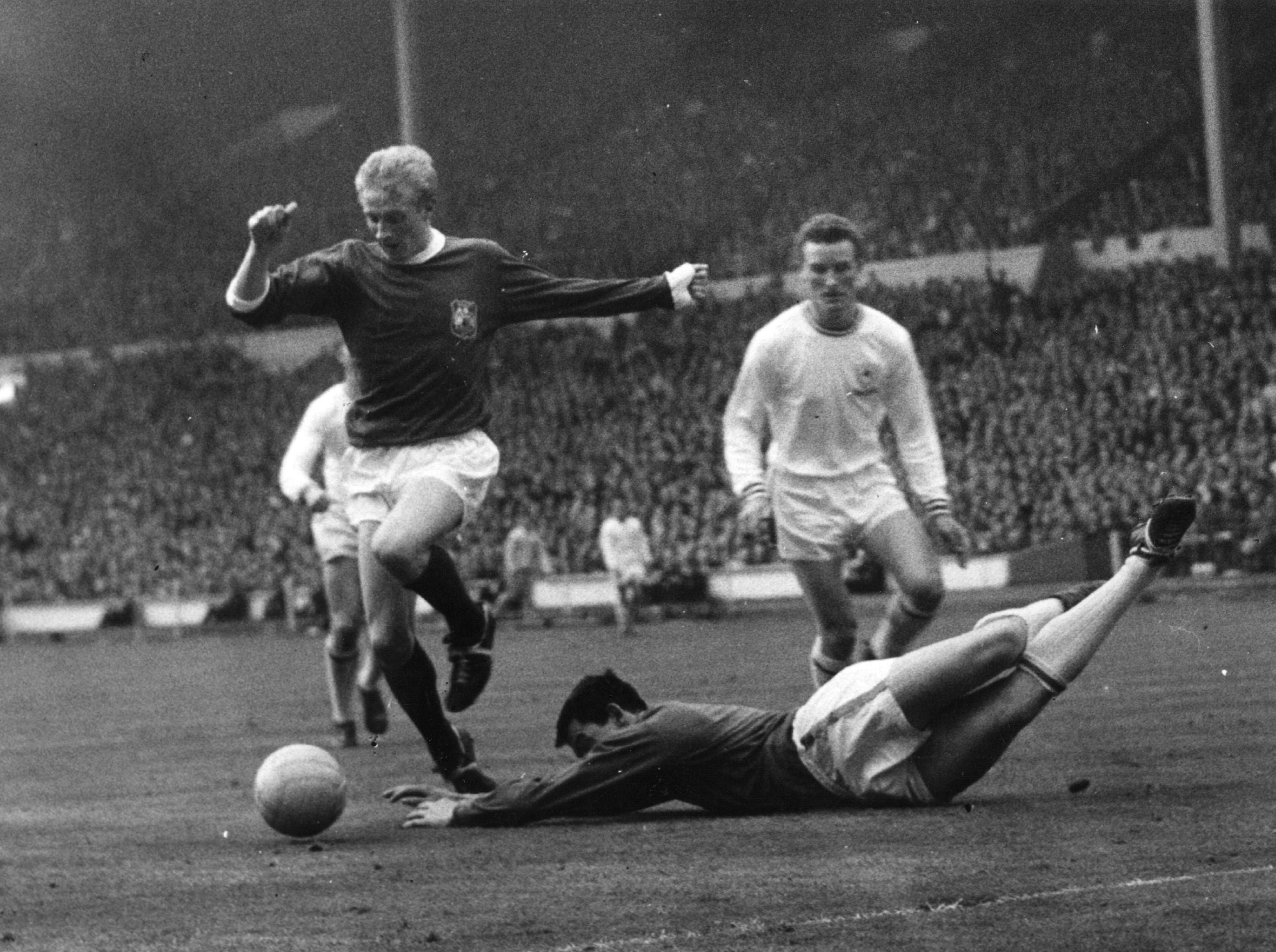 Manchester United’s Denis Law dribbles around Leicester goalkeeper Gordon Banks during the 1963 FA Cup final at Wembley