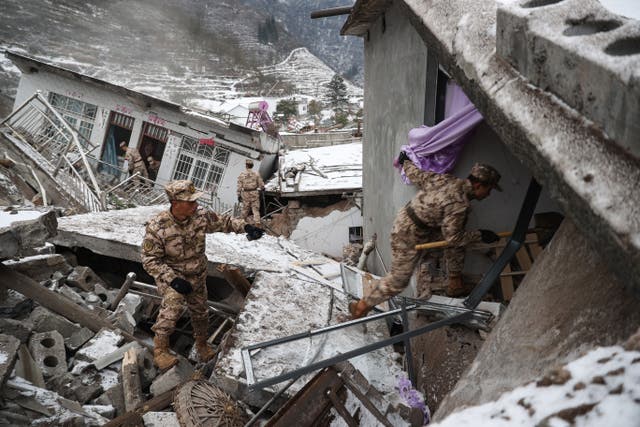 <p>This picture taken on 22 January 2024 shows Chinese military police and rescue workers searching for missing victims at a landslide site in Liangshui village in Zhaotong, in southwestern China’s Yunnan province.</p>