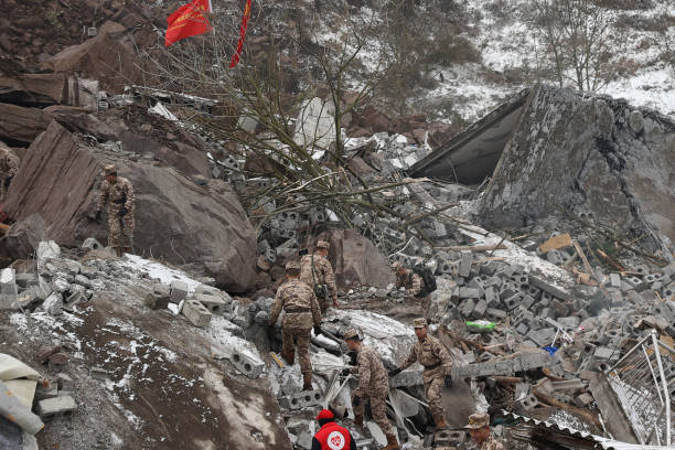 This picture taken on 22 January 2024 shows Chinese military police and rescue workers searching for missing victims at a landslide site in Liangshui village in Zhaotong, in southwestern China’s Yunnan province