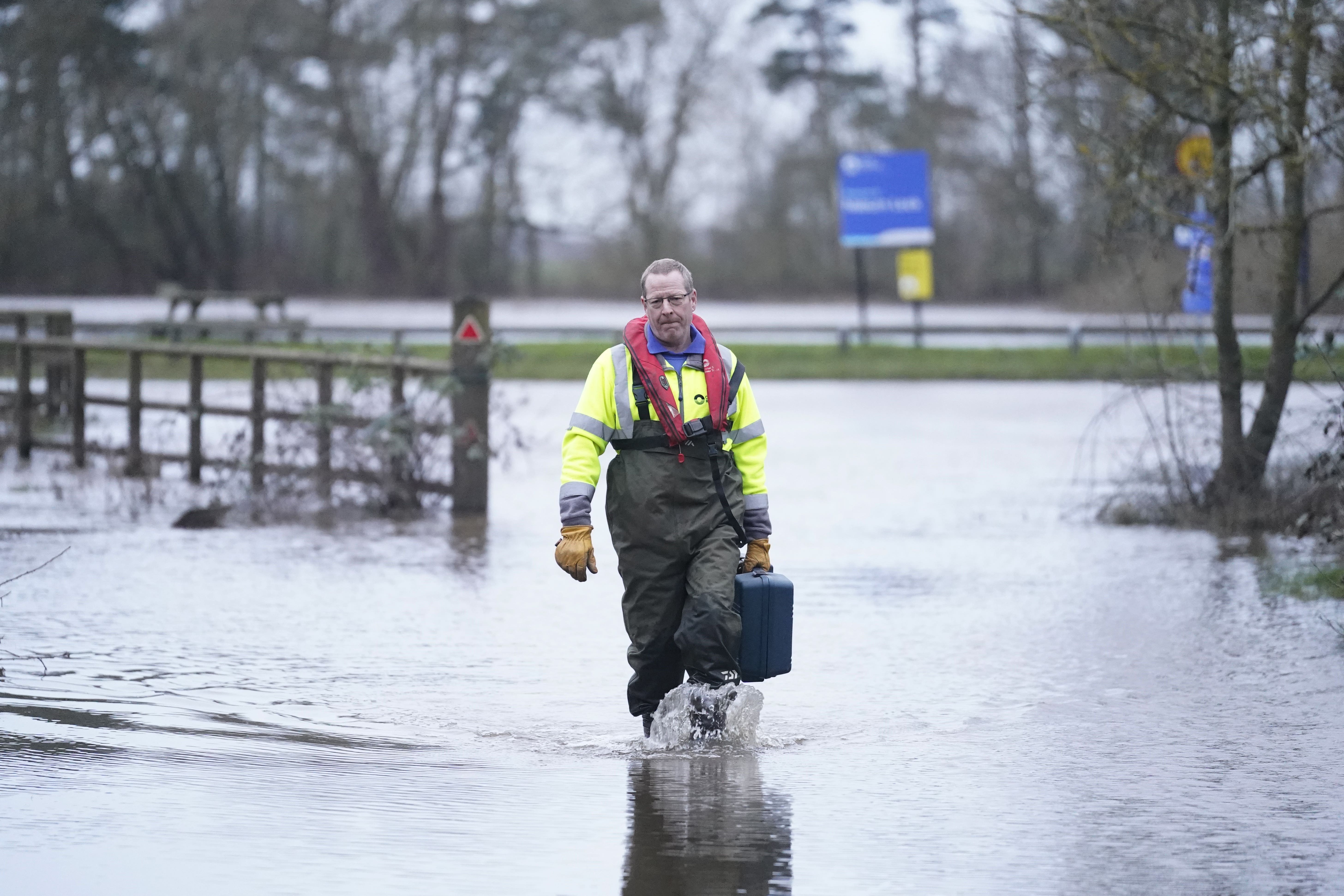 A Canal and River Trust worker walks through flood water at Naburn Lock on the outskirts of York (Danny Lawson/PA)