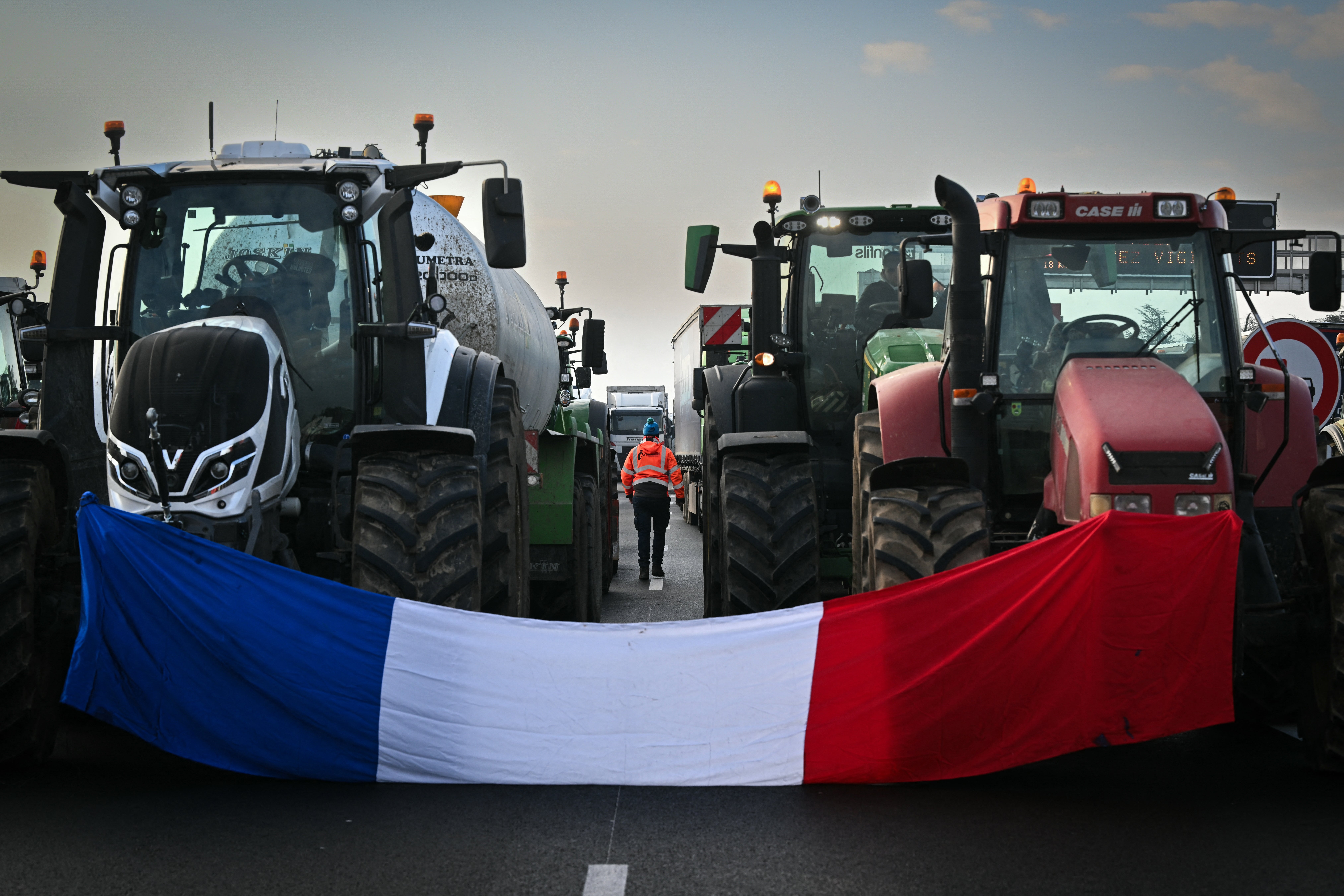 The French national flag drapped between two tractors as farmers block the A7 motorway near Albon, southeastern France.