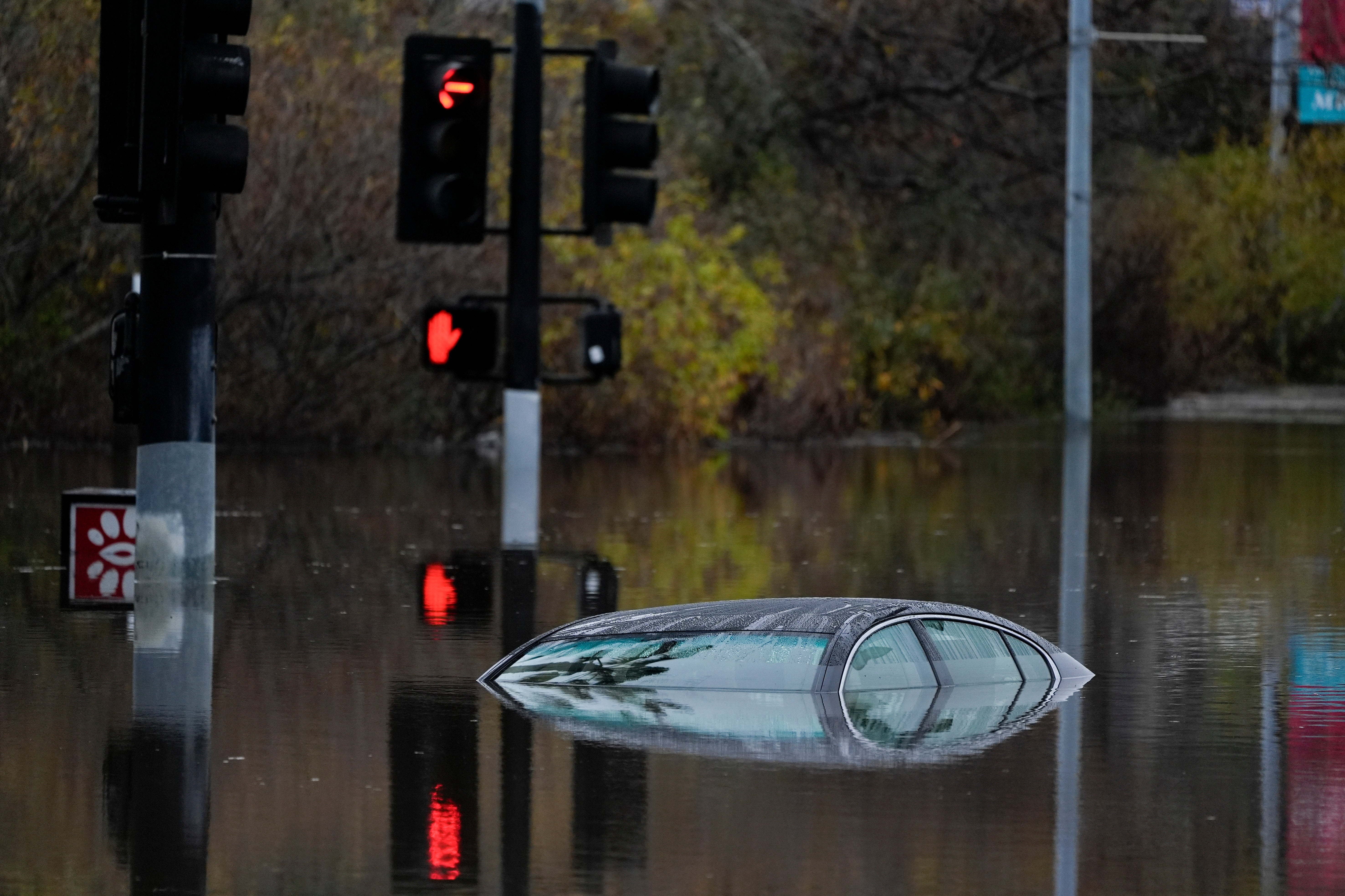 A car sits along a flooded road during the rainstorm in San Diego