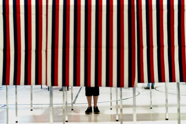 <p>A voter stands in a booth at a polling site while filling out their ballot in the New Hampshire presidential primary in Manchester, N.H., Tuesday 23 January 2024</p>