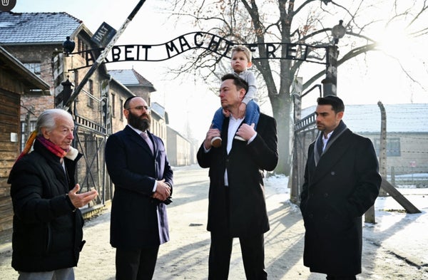 Musk carries his son on his shoulders at Auschwitz, just metres from where thousands of Jewish prisoners were murdered 