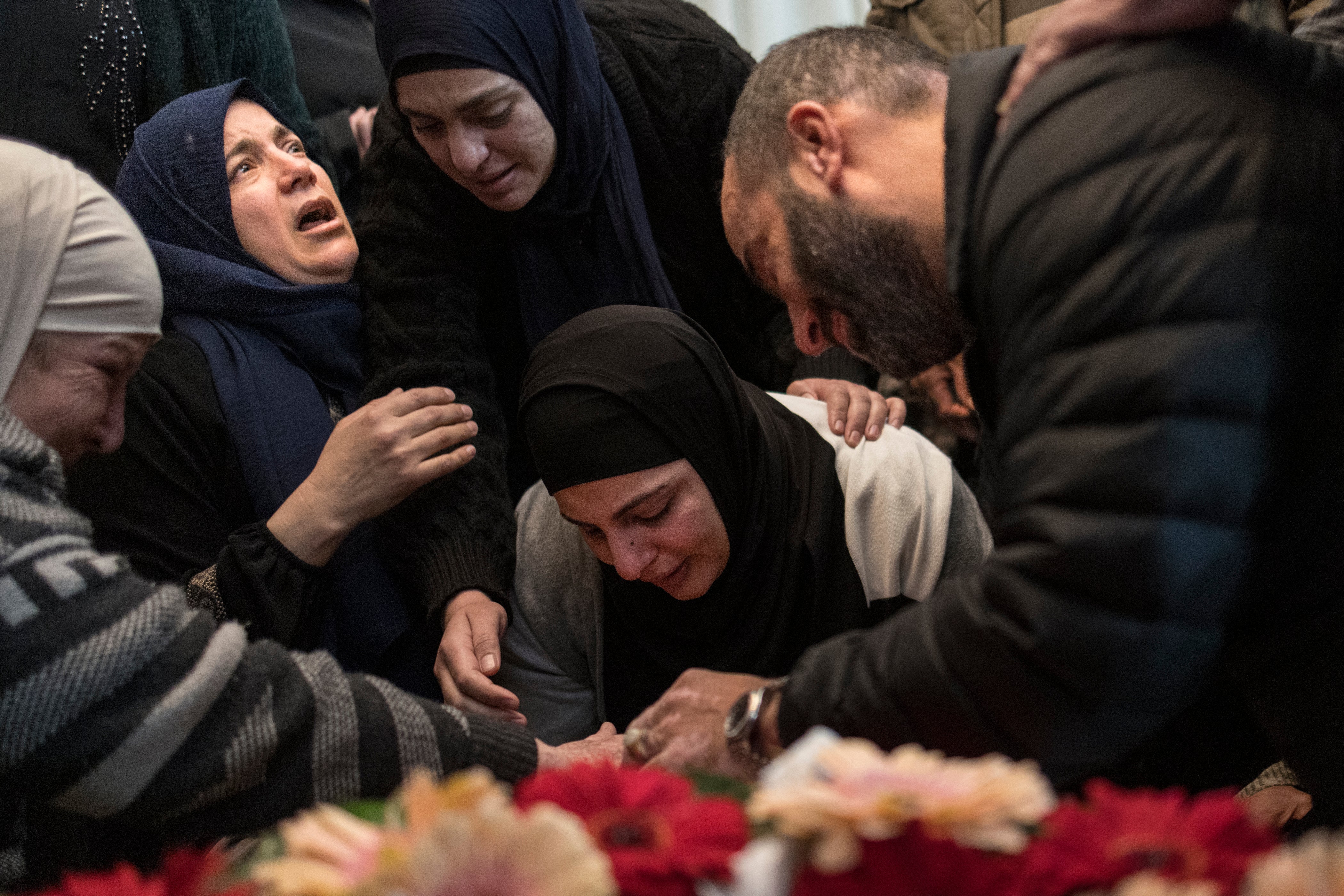 The mother of 17-year-old Palestinian Tawfic Abdel Jabbar mourns over his body before a funeral procession in the Israeli-occupied West Bank on 20 January.