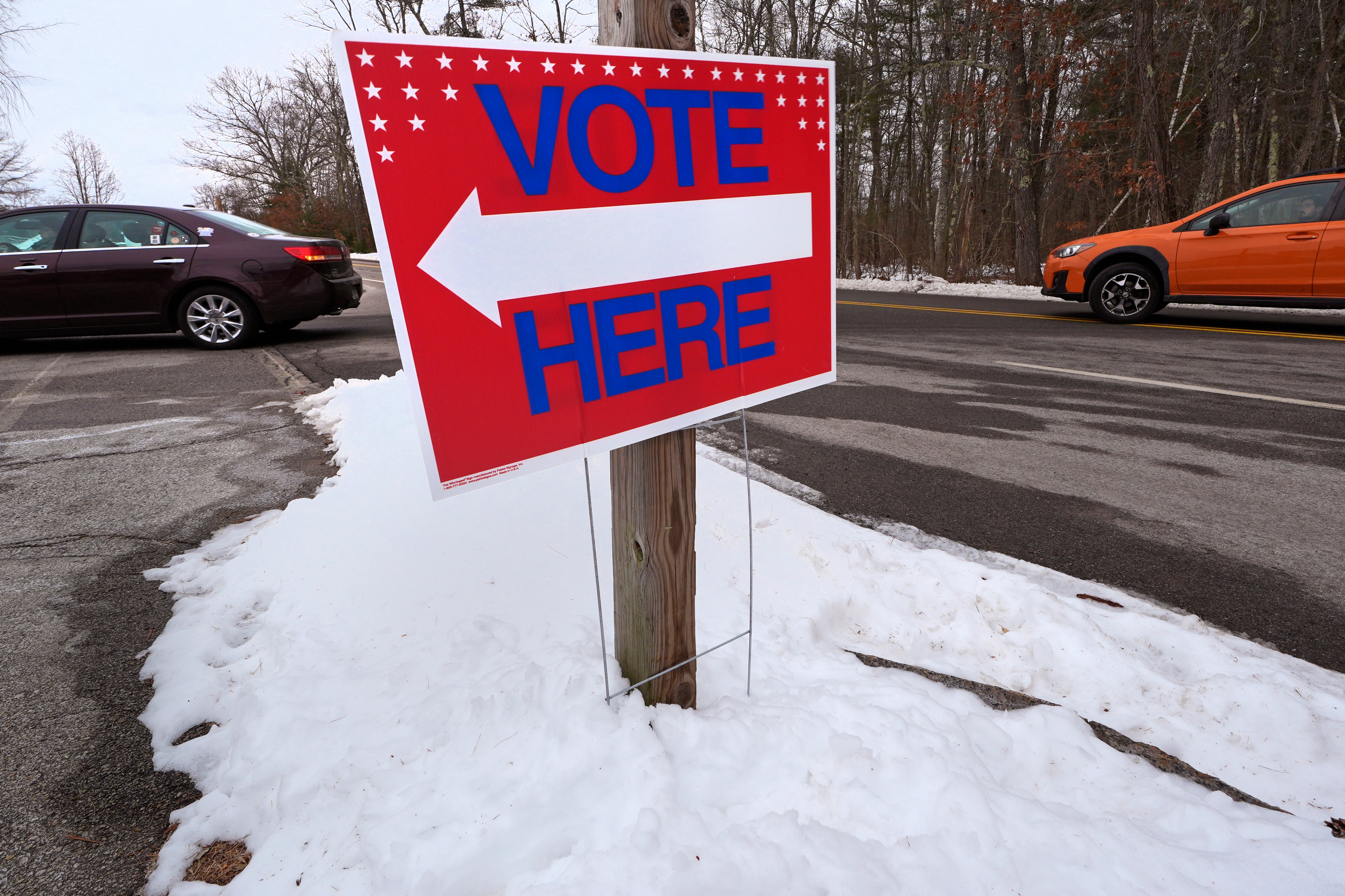 Drivers follow the arrows to cast their vote, in Auburn, New Hampshire