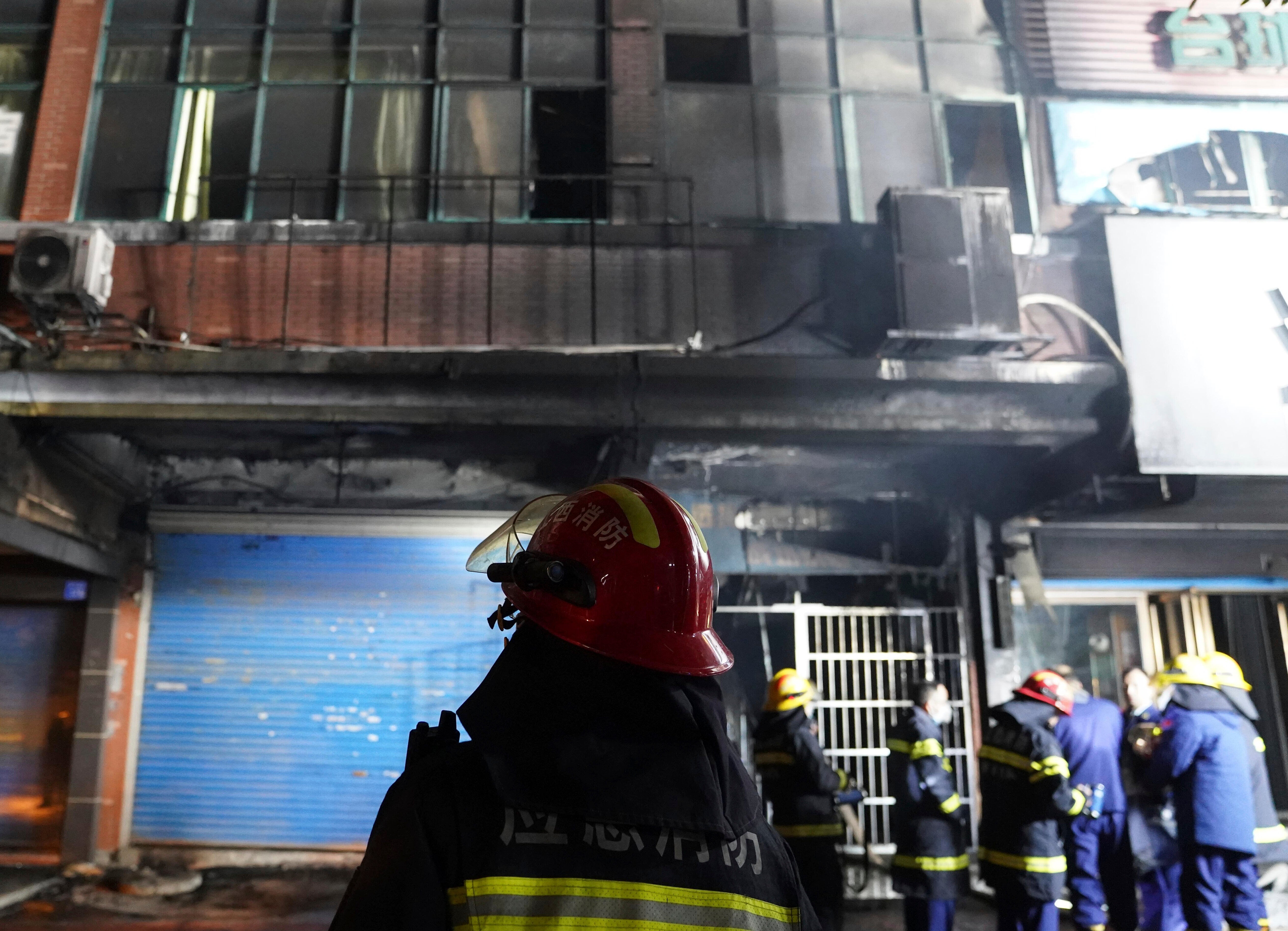 Firefighters work at the site of a building fire in Xinyu City, east China's Jiangxi Province