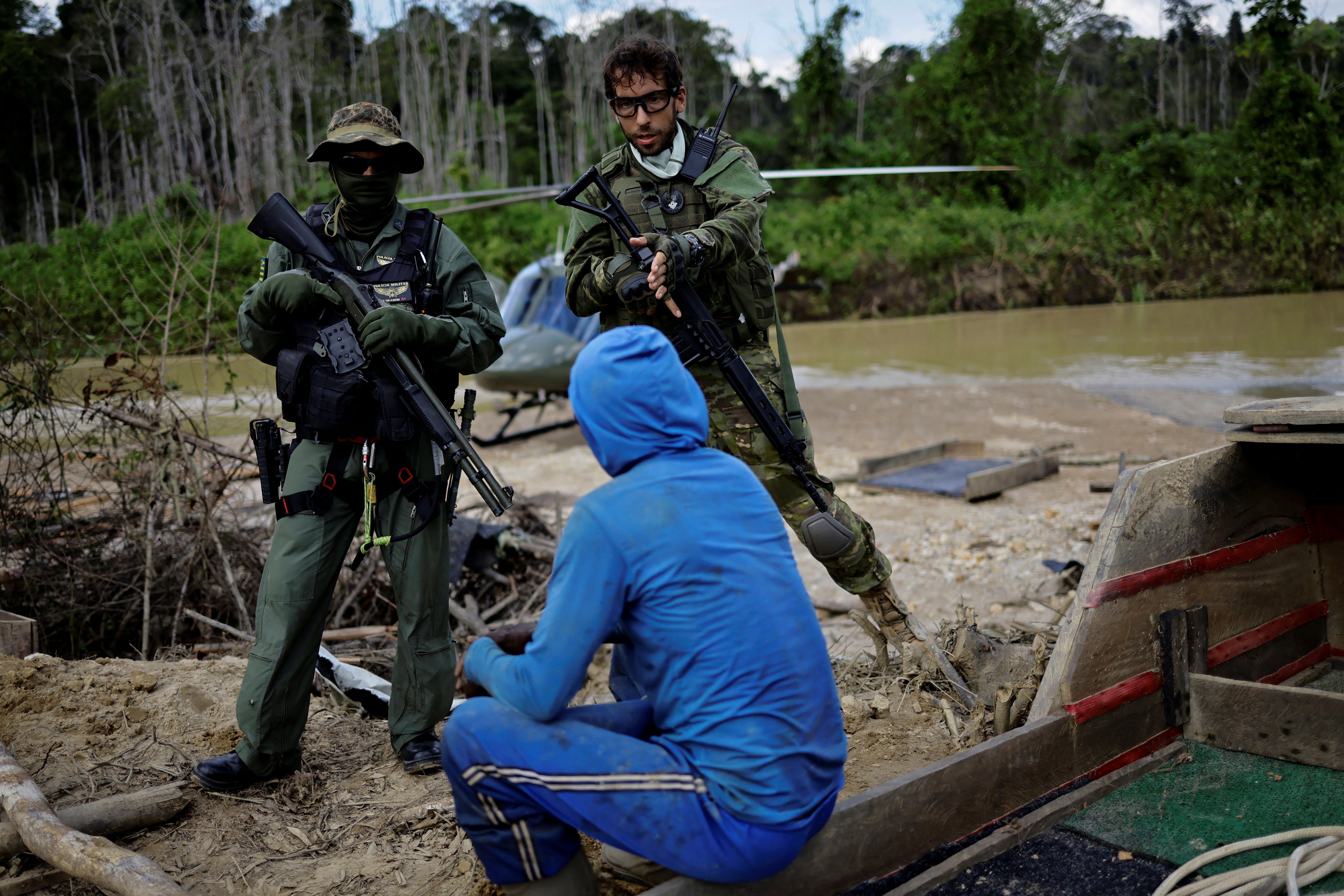 An Ibama inspector talks with an illegal miner while he is detained