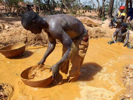 A gold miner pans for gold in Mali