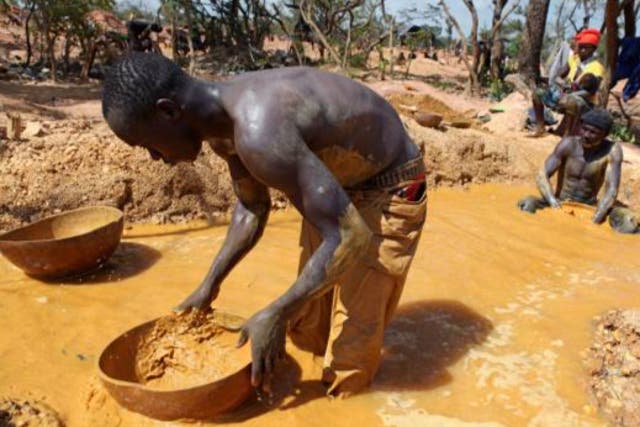 <p>A gold miner pans for gold in Mali</p>