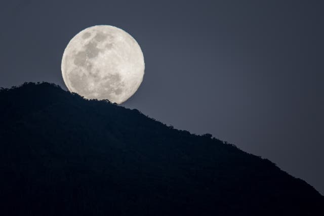 <p>A full moon behind Waraira Repano National Park, in Caracas, Venezuela, in January 2024 </p>