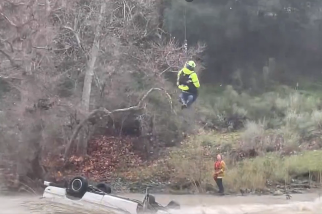 <p>Woman being rescue by California Highway Patrol official</p>