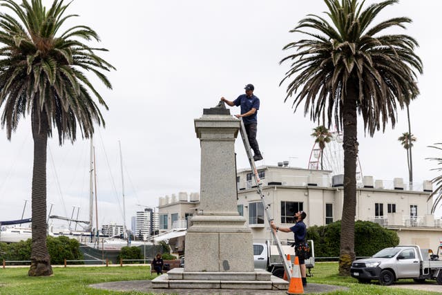 <p>Workers remove the remnants of a Captain Cook statue in Melbourne</p>