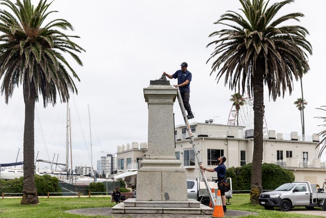 <p>Workers remove the remnants of a Captain Cook statue in Melbourne</p>