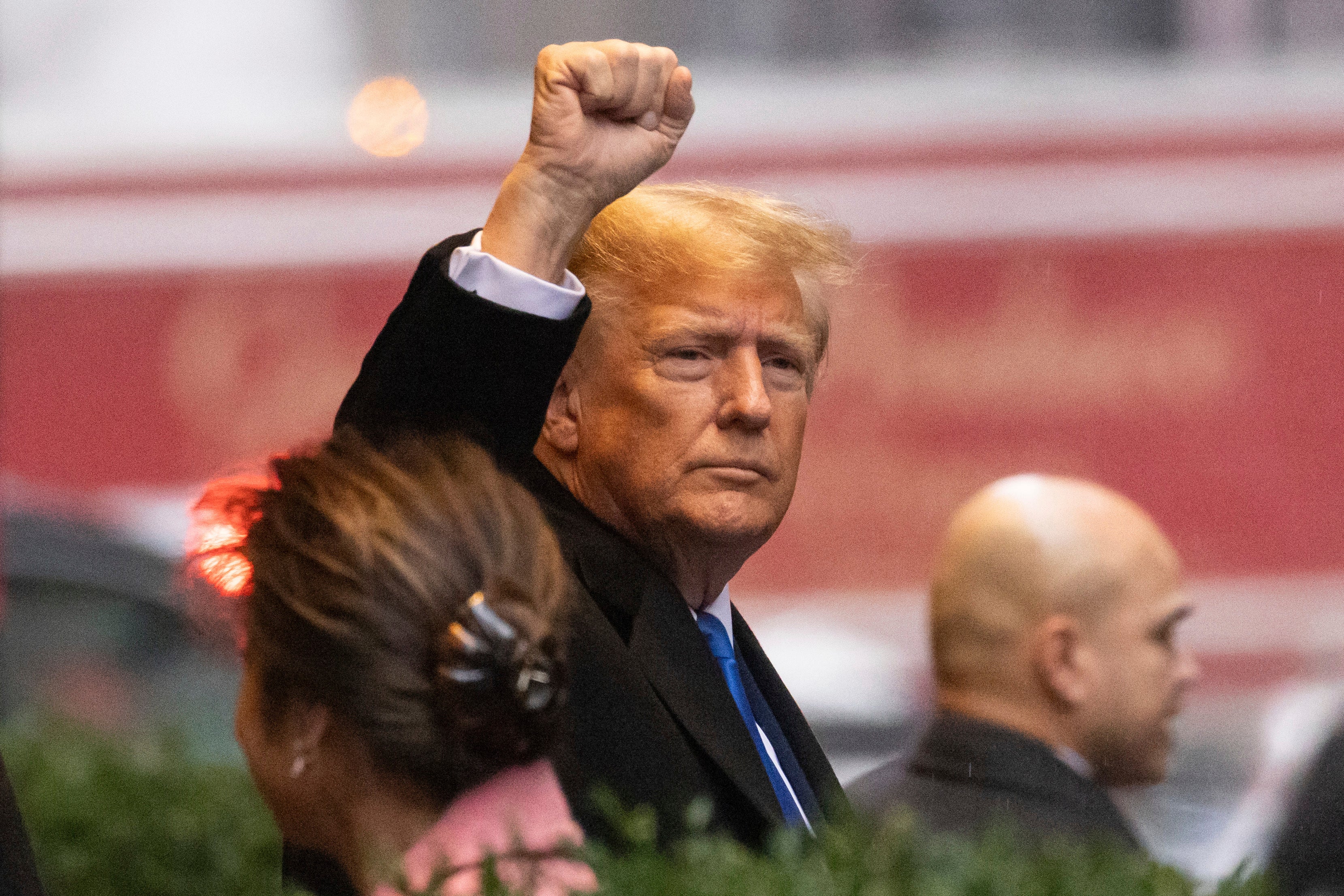 Trump raises his fist as he leaves his apartment