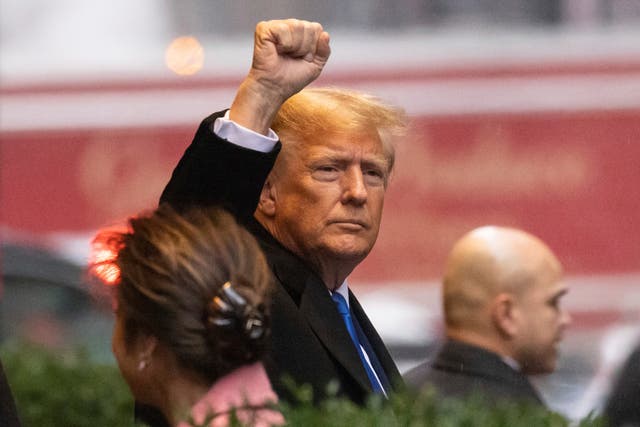 <p>Trump raises his fist as he leaves his apartment </p>