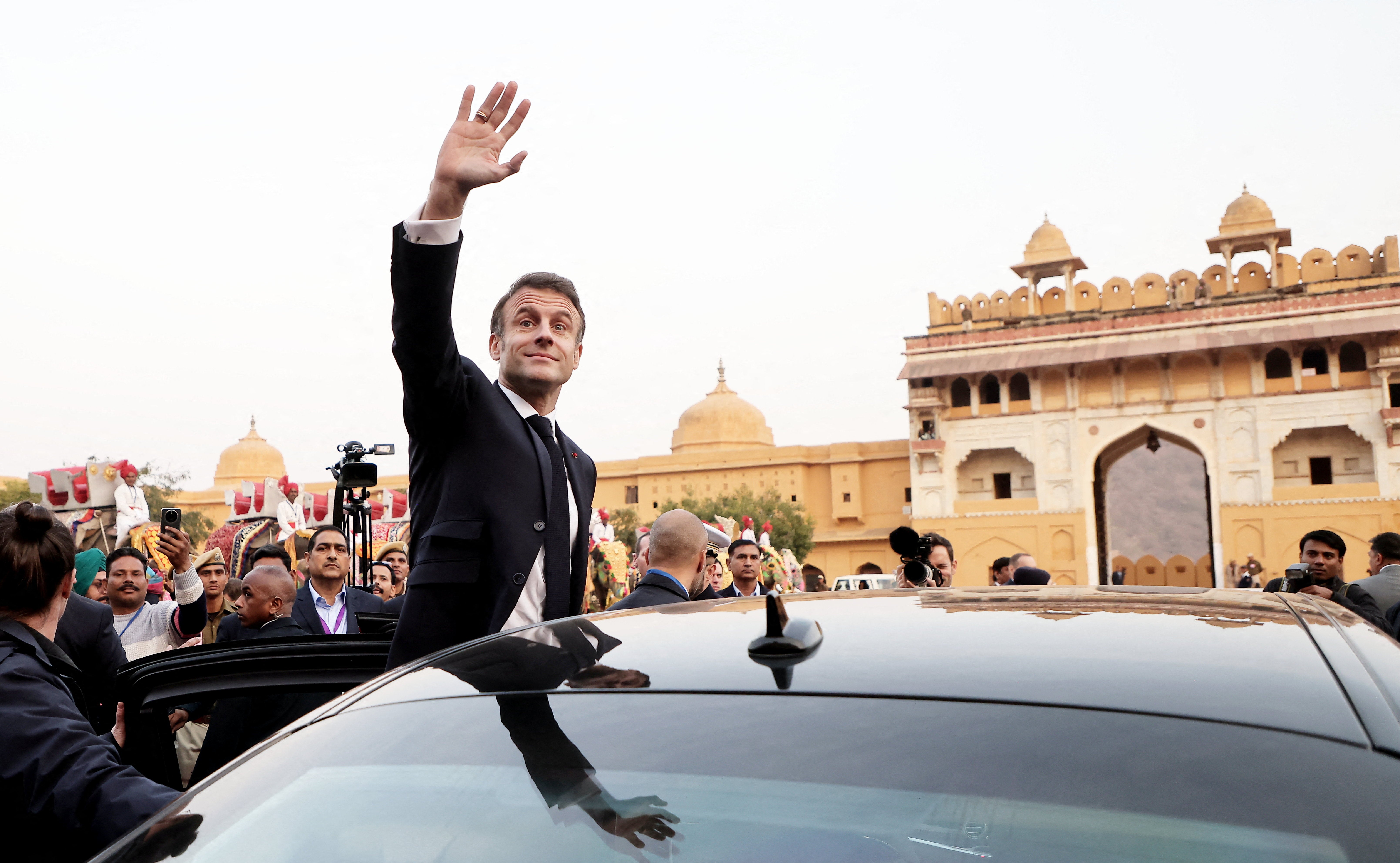 French President Emmanuel Macron waves as he attends a welcoming ceremony at Amber Fort in Jaipur