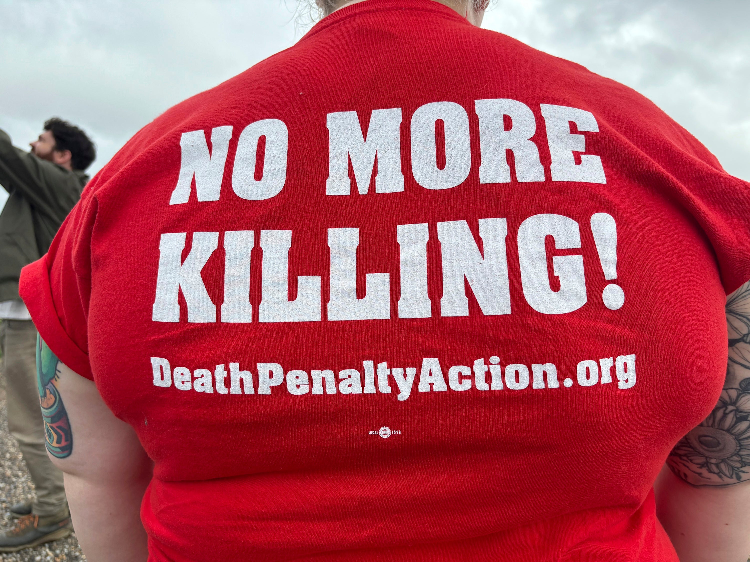 Anti-death penalty activists place signs along the road heading to Holman Correctional Facility