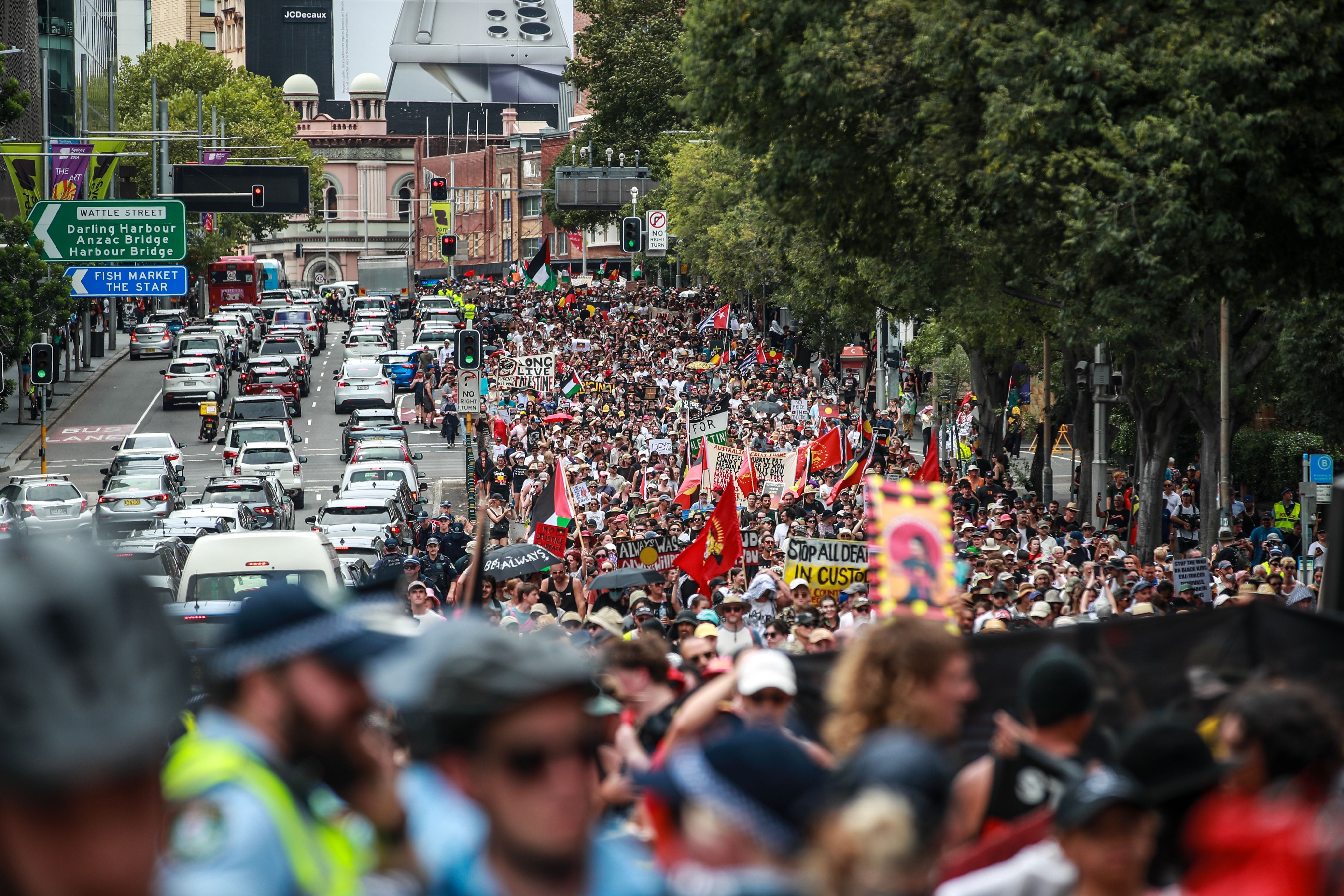 Demonstrators march towards Victoria Park during an Invasion Day protest