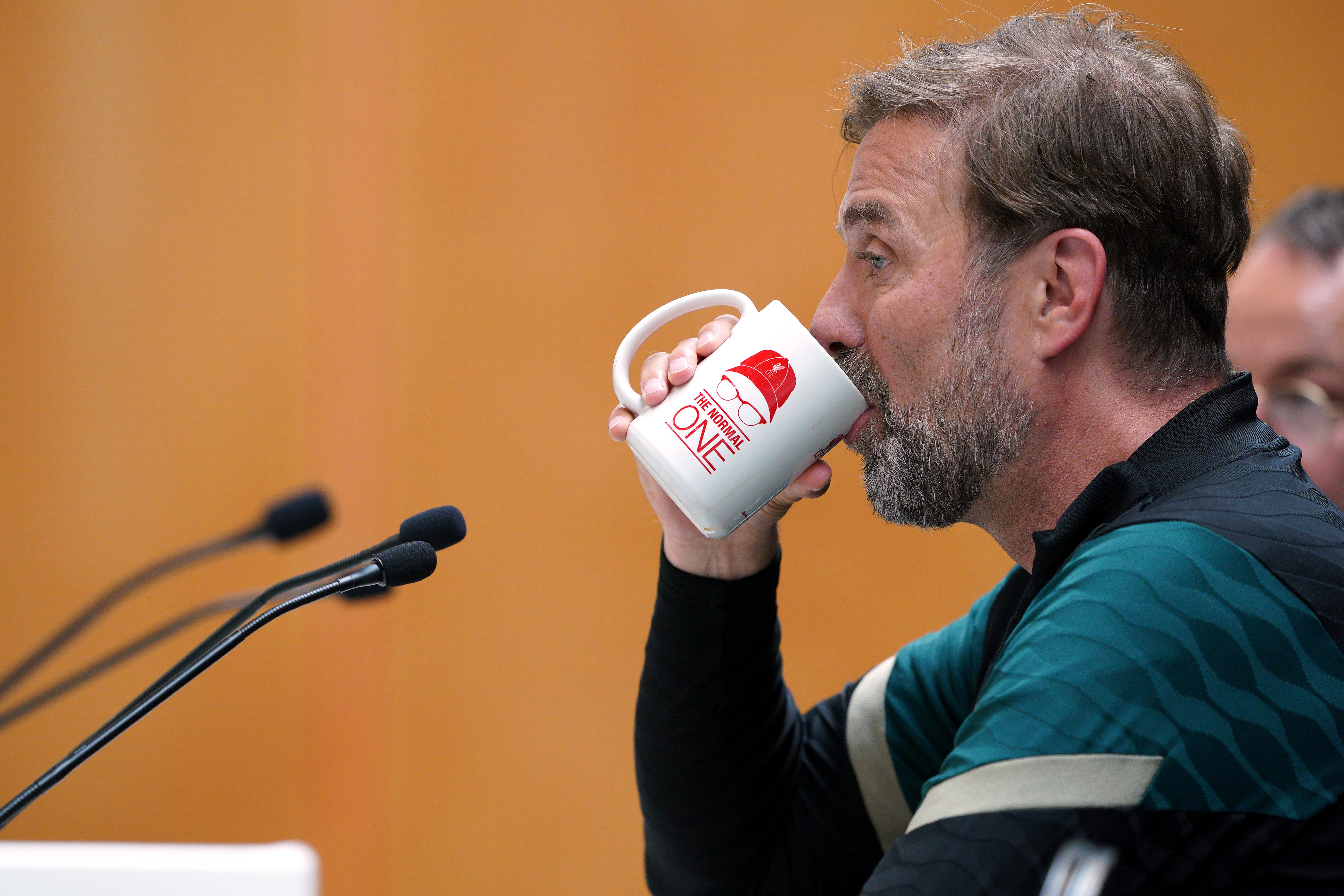 Liverpool manager Jurgen Klopp using a mug with The Normal One on it during a press conference as part of a media day at the AXA Training Centre in Liverpool ahead of the UEFA Champions League Final in Paris on Saturday. Picture date: Wednesday May 25, 2022.