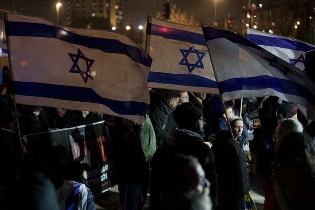 <p>Holding up Israeli flags people take part in a protest against humanitarian aid entering Gaza and against the hostages exchange deal with Hamas, in Jerusalem, Israel, Thursday, Jan. 25, 2024</p>