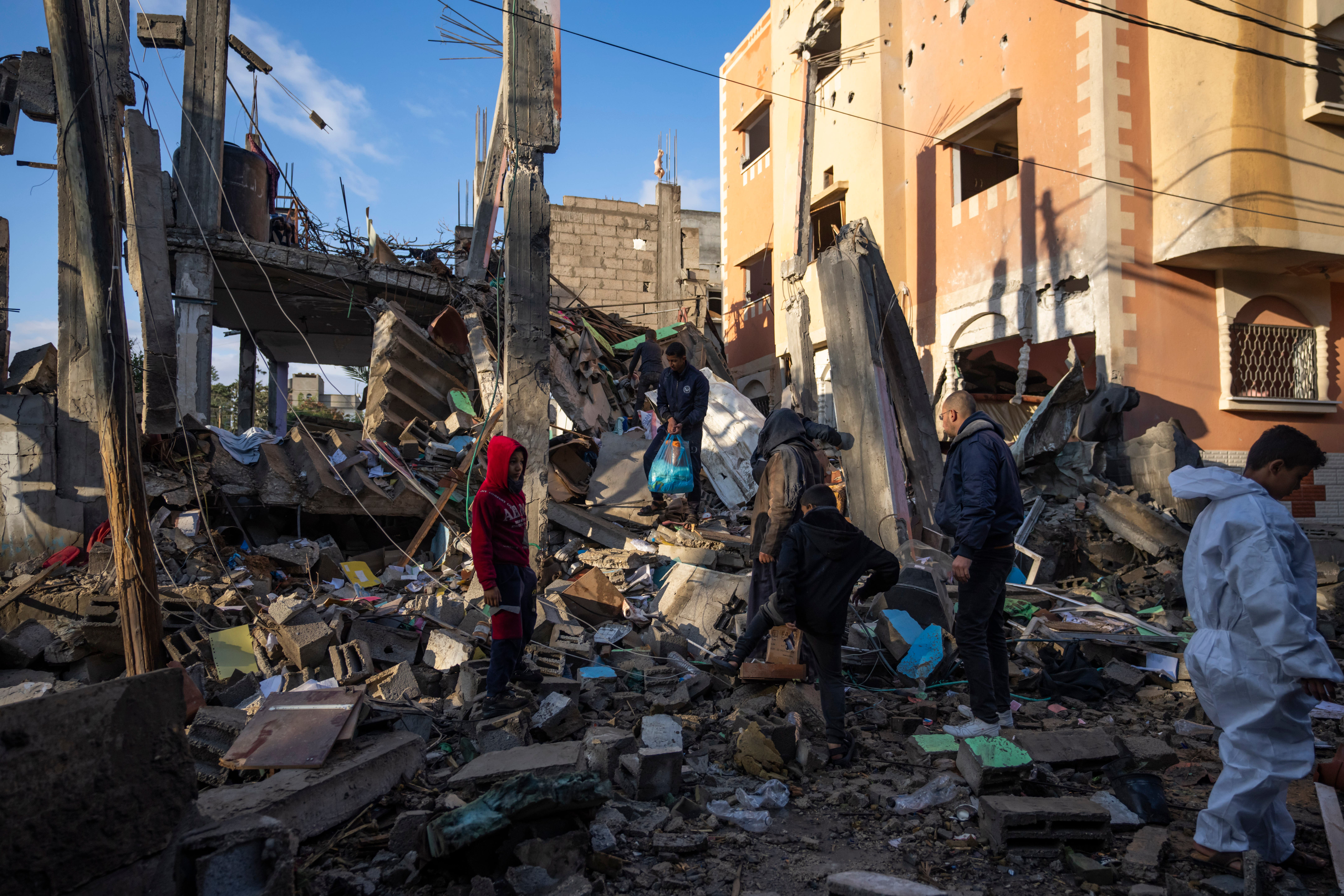 Palestinians look at the destruction after an Israeli strike in Rafah, southern Gaza Strip (Fatima Shbair/AP)