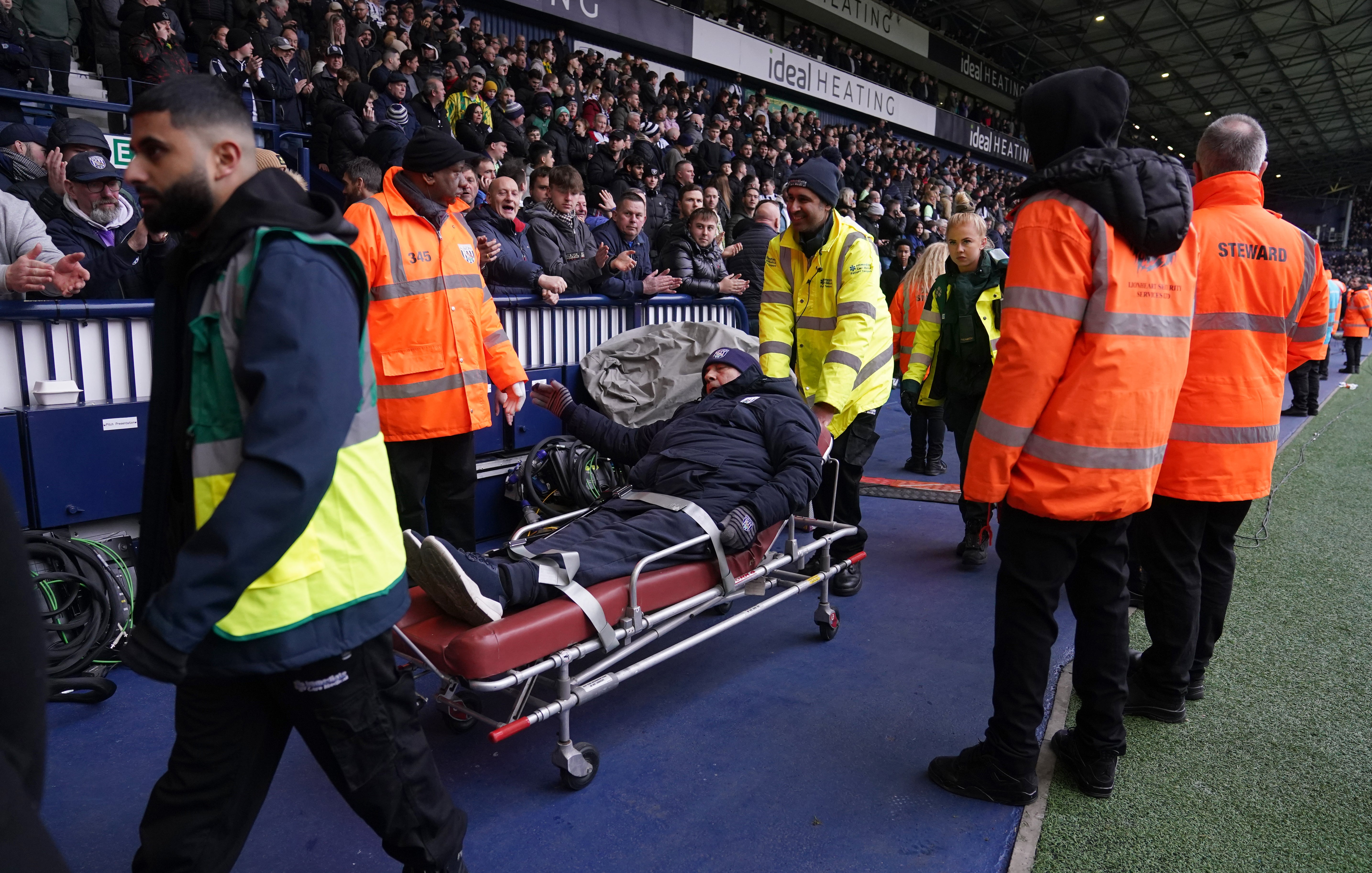 A fan is stretchered out of the ground following clashes in the stands