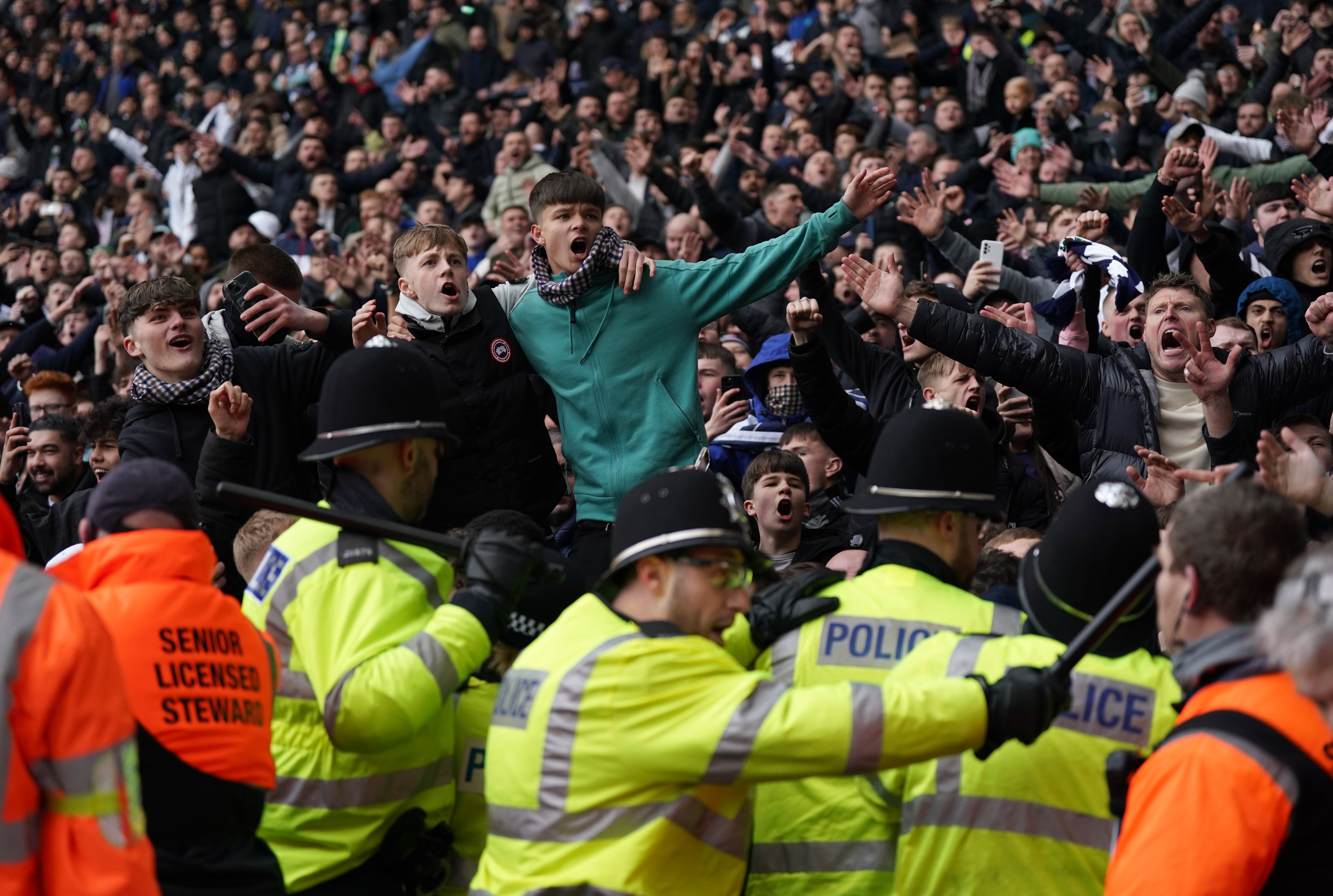 Fans invading the pitch clash with police officers
