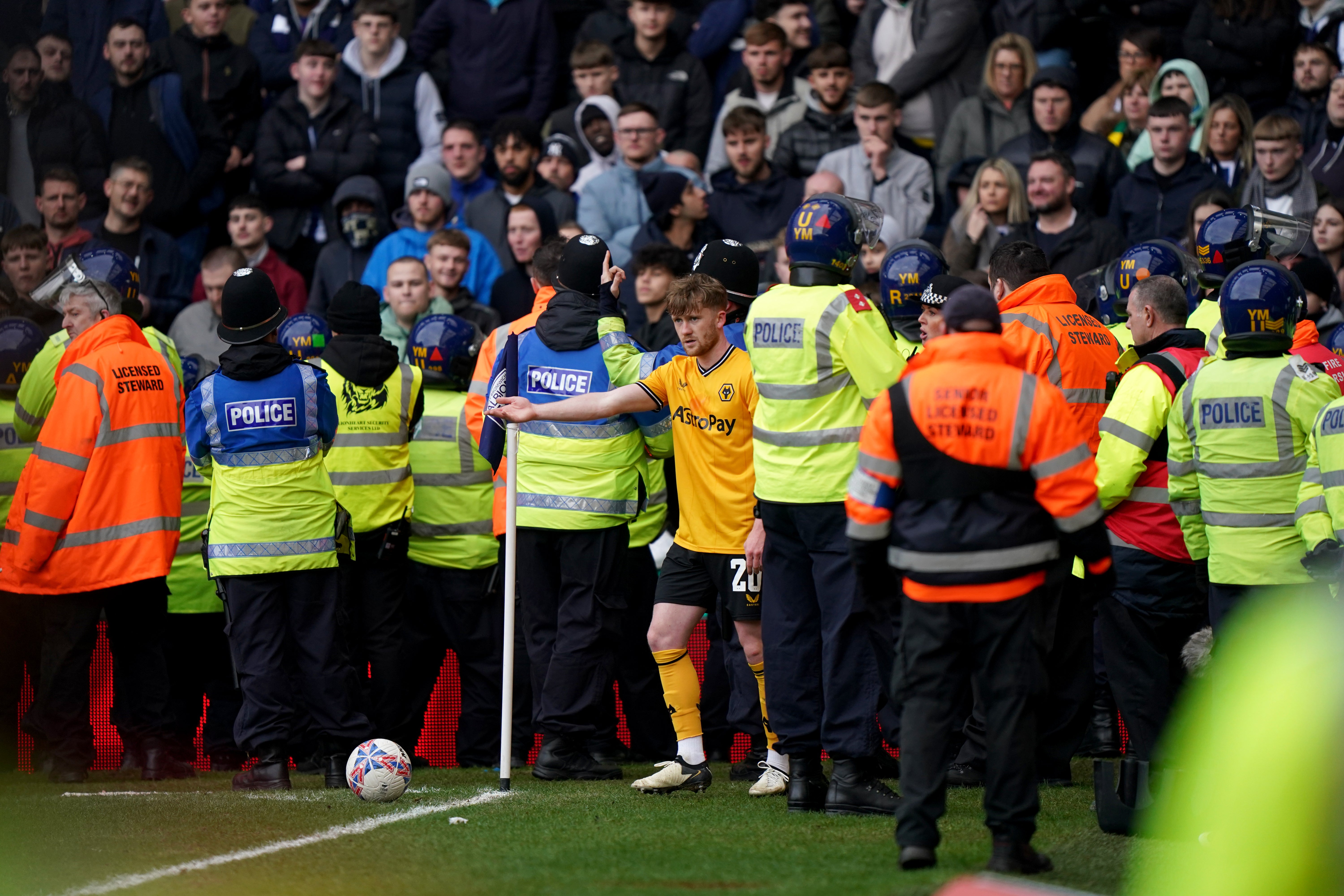 Wolves’ Tommy Doyle attempts to take a corner while surrounded by police officers and stewards during the Emirates FA Cup fourth-round match at the Hawthorns